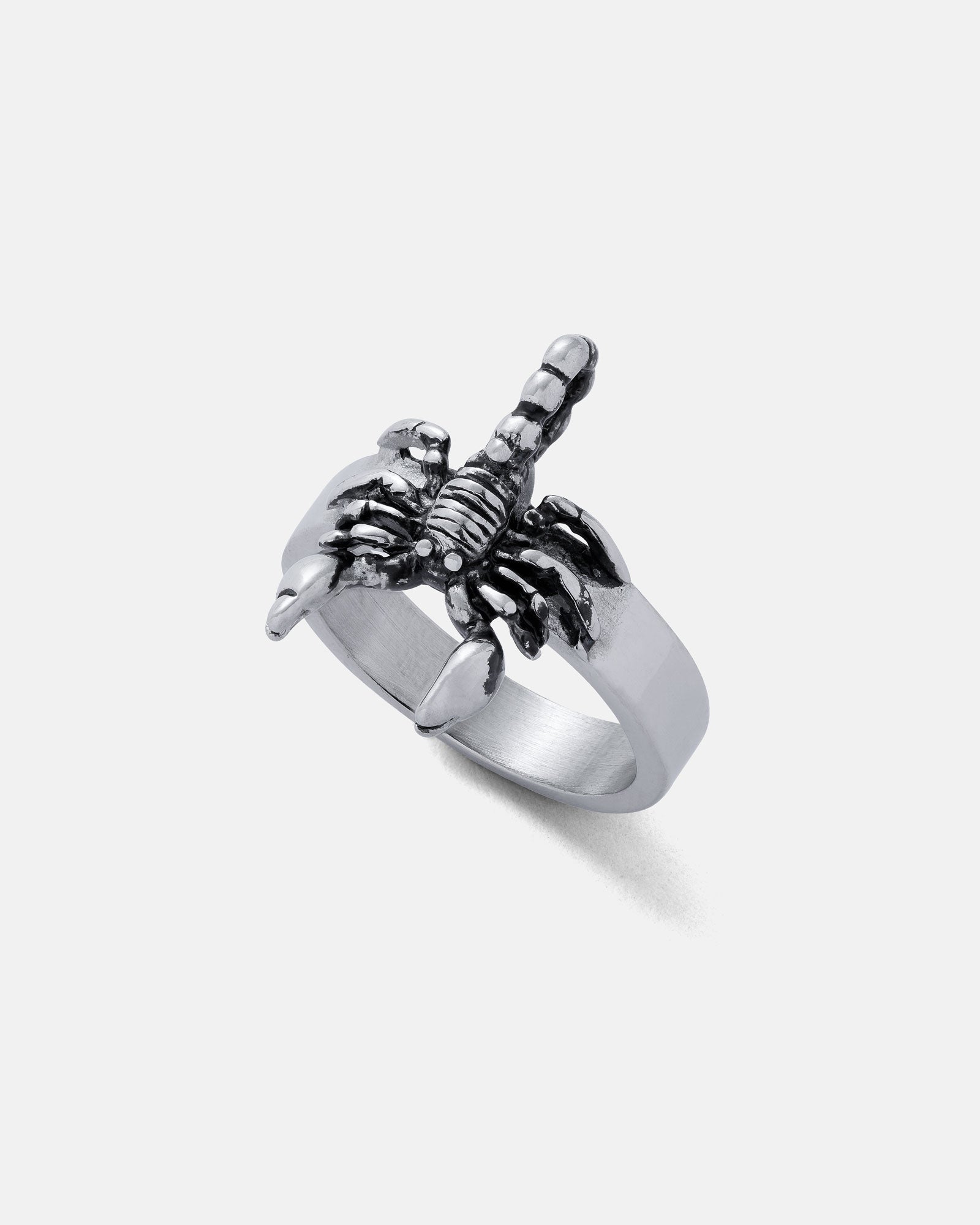 The Scorpion Ring, crafted in silver with a raised scorpion and arched tail over the band, is a bold piece of jewelry that stands out against a plain white background.