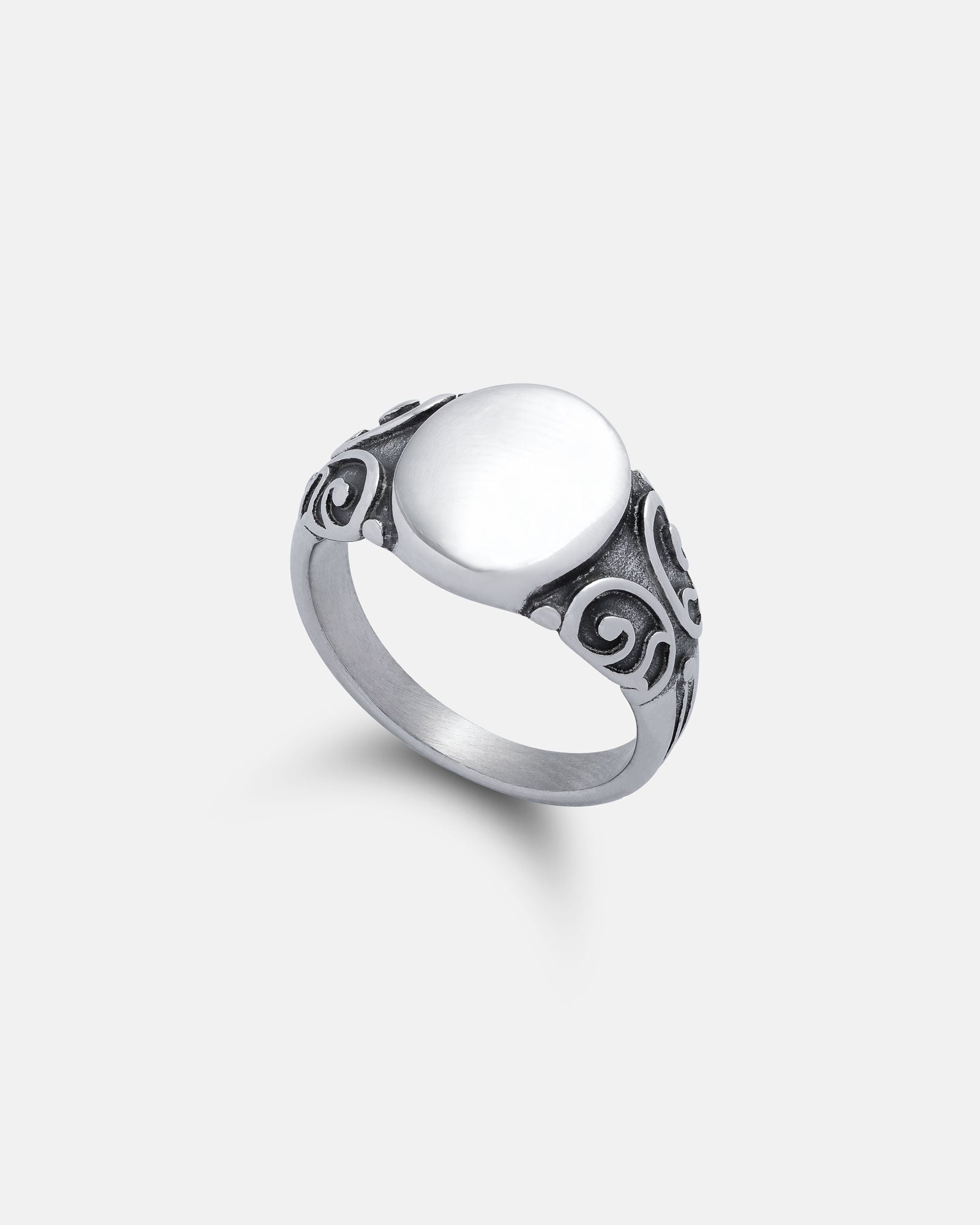 The Mini Oval Scroll Signet Ring features a stainless steel, smooth oval top and ornate swirling scroll patterns on the shank, displayed against a plain white background.