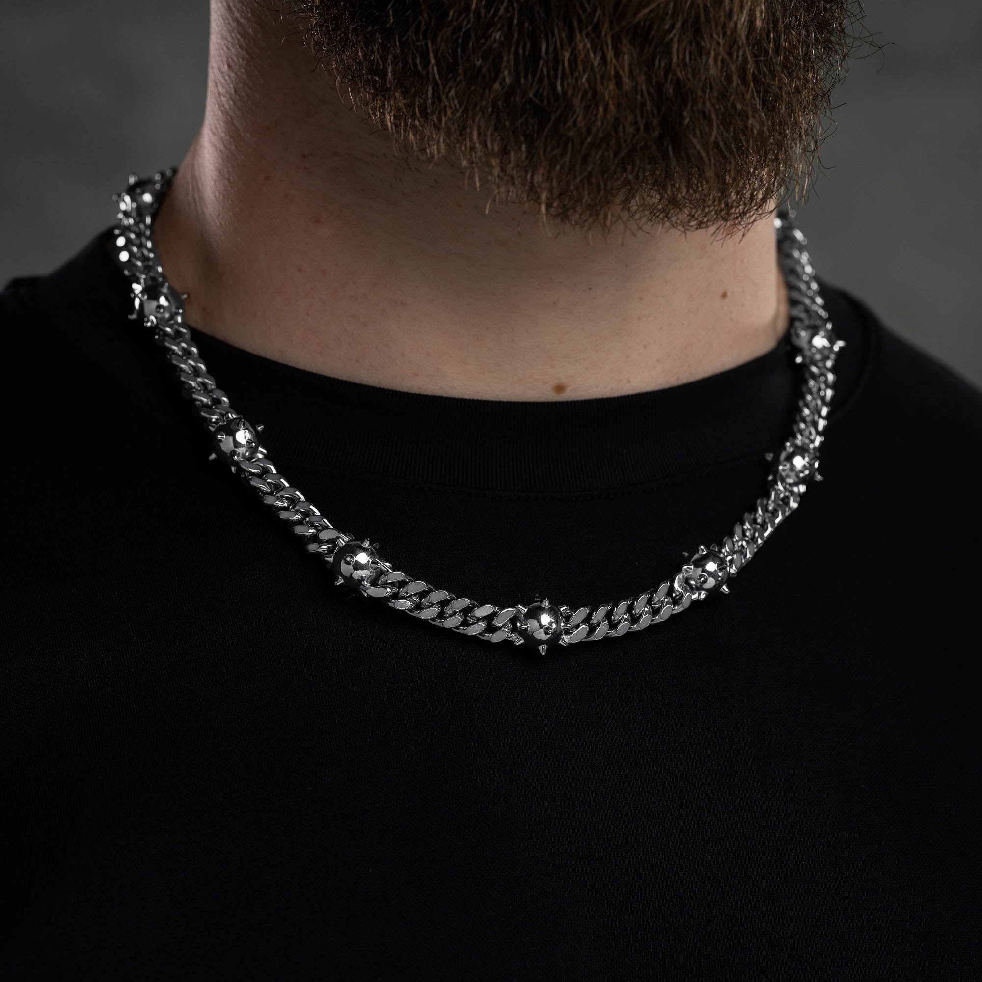 Silver Cuban Chain with spiked ball links, on male neck with black t shirt by statement collective
