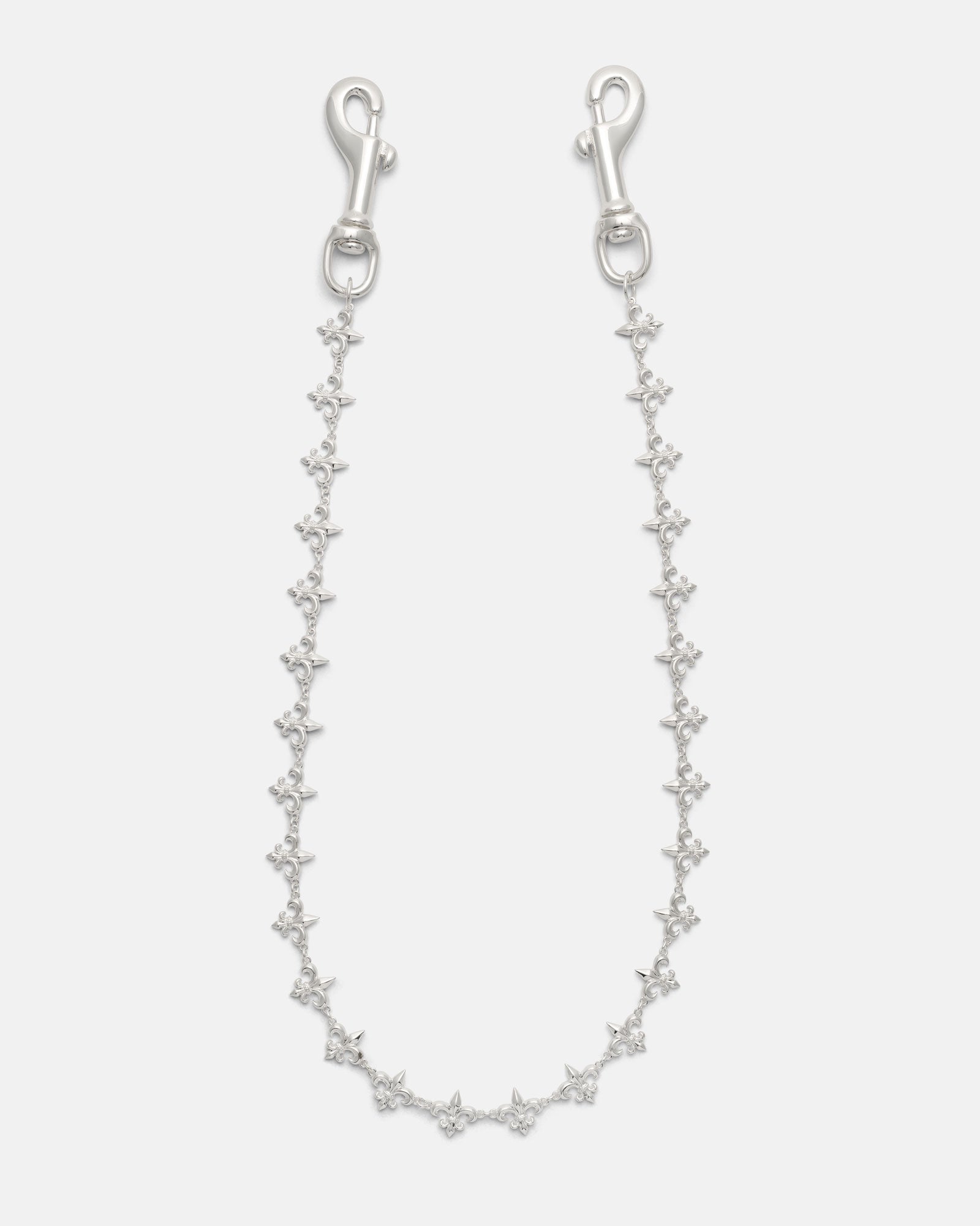 Introducing the “Fleur De Lis” Wallet Chain by Statement Collective—a delicate silver accessory featuring small, evenly spaced star-shaped links and metal clasps at each end. Displayed against a white background, its intricate design evokes refined elegance and offers a subtle nod to the classic motifs found in traditional Fleur De Lis wallet chains.