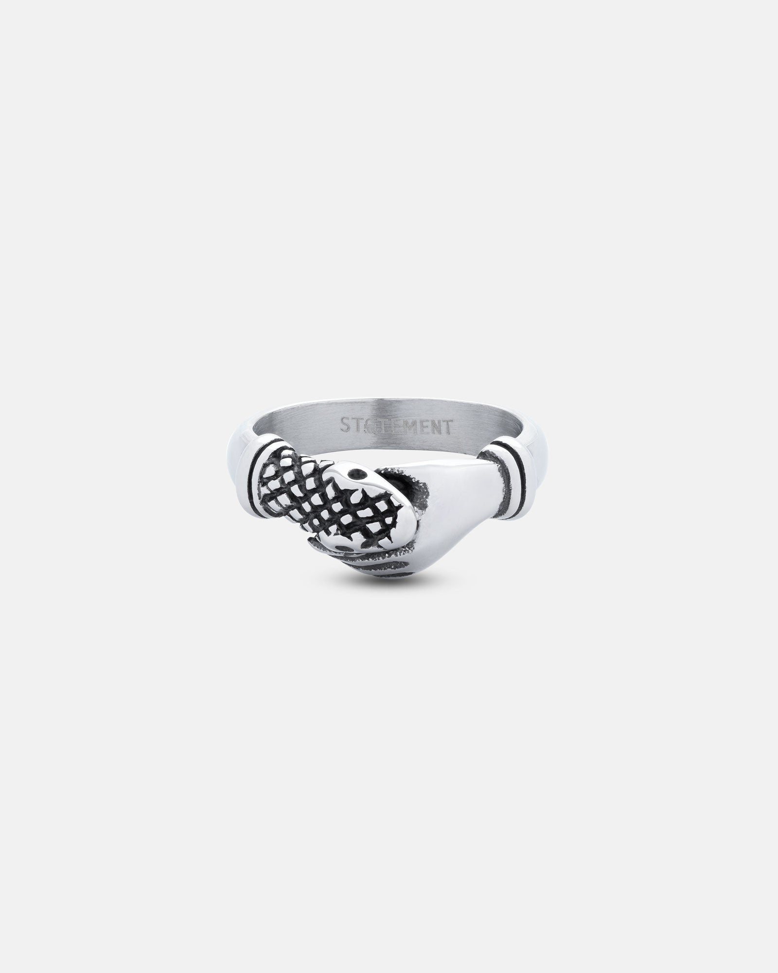 Introducing "The Hand That Bites" Ring—a silver stainless steel ring with two clasped hands, one featuring a grid-like texture. This distinctive design pops against a plain white background.
