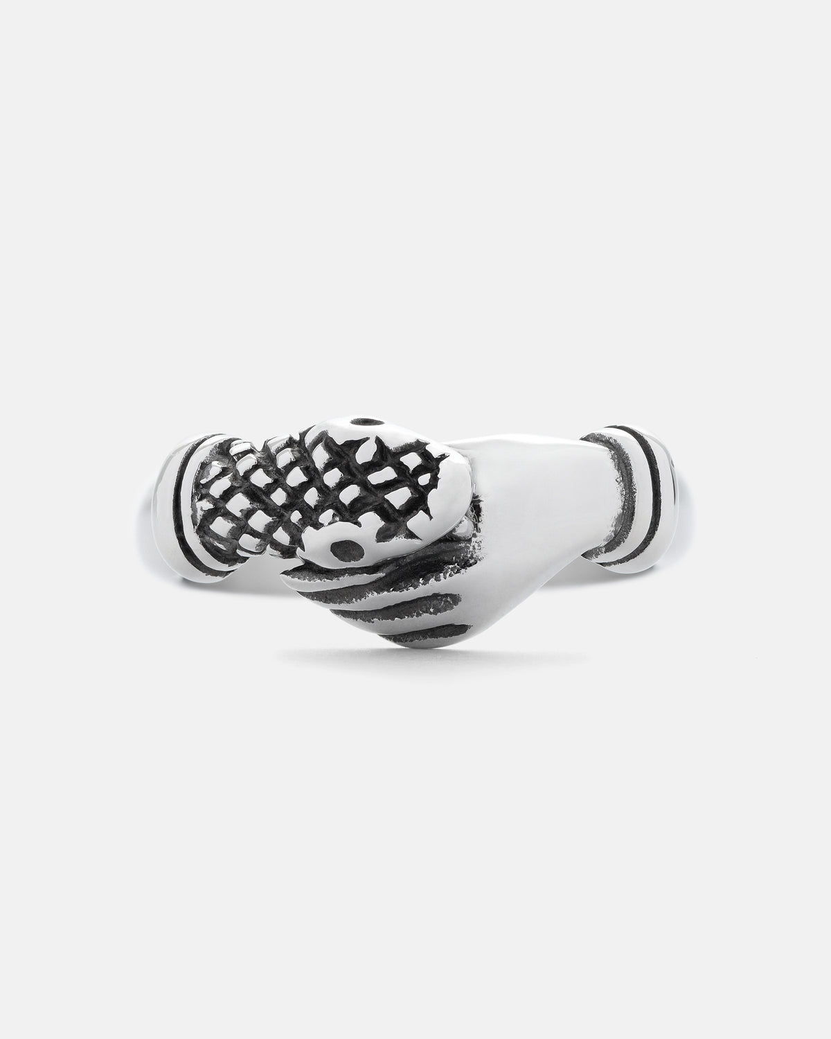 Statement Collective’s “The Hand That Bites” Ring is crafted in silver stainless steel and showcases two hands clasped together in a handshake—one of which is adorned with a textured glove featuring a subtle snakeskin pattern—all set against a plain light gray background.