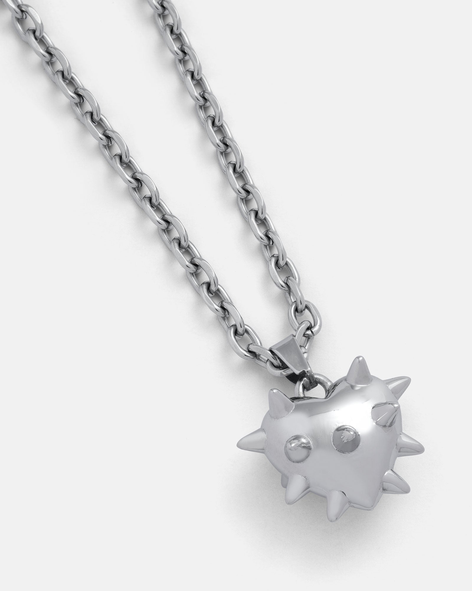 The "Love Hurts" Spiked Heart Pendant features a shiny silver heart with small spikes, ideal for grunge jewelry fans. Displayed on a plain light gray background.