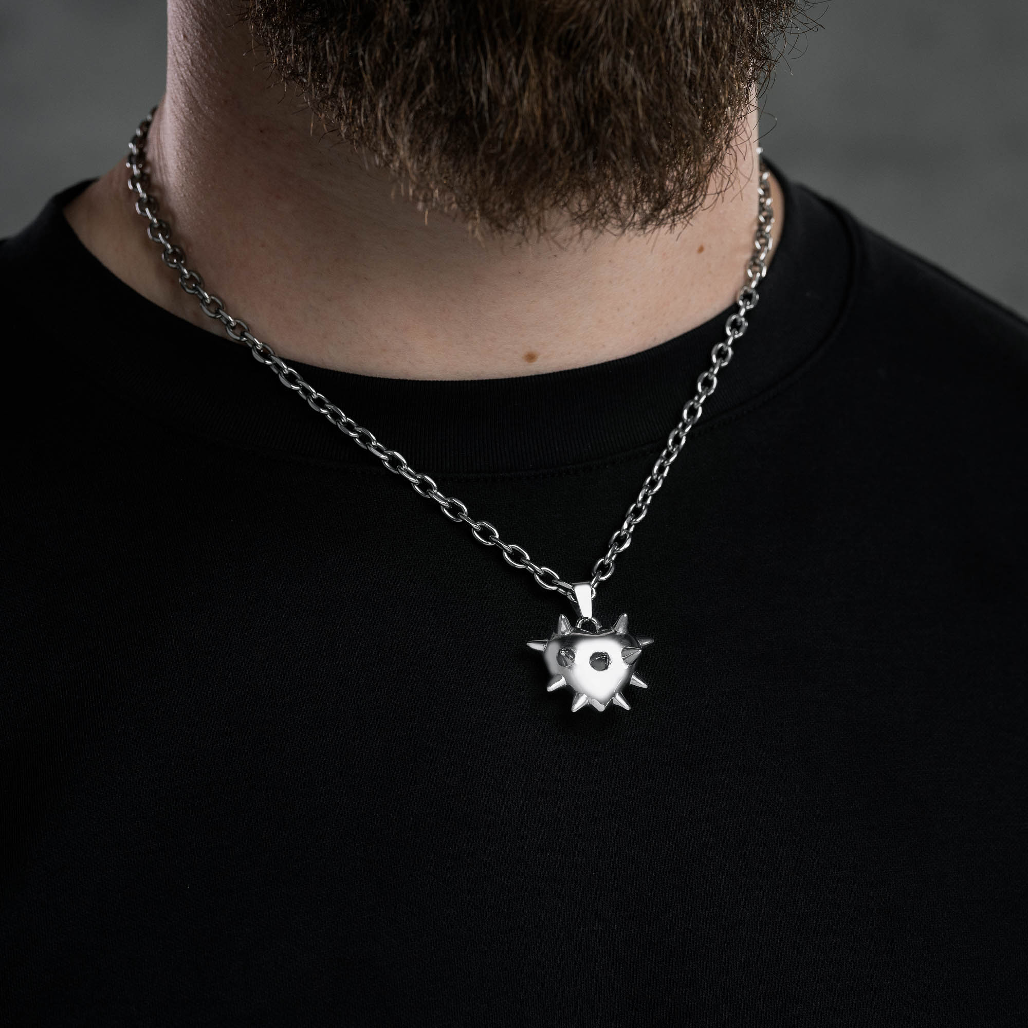 spiked heart pendant on cable link chain on male black t shirt