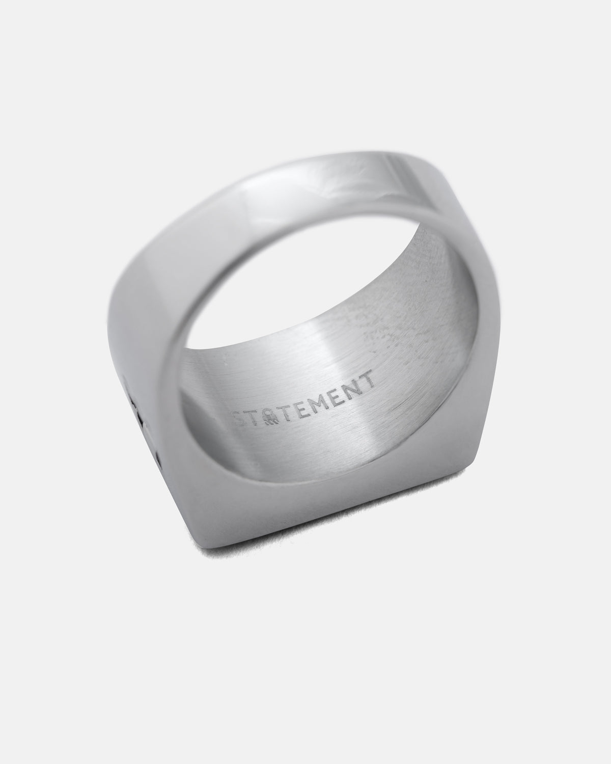 Silver-toned minimalist Statement Signet Ring angled to show the interior engraving.