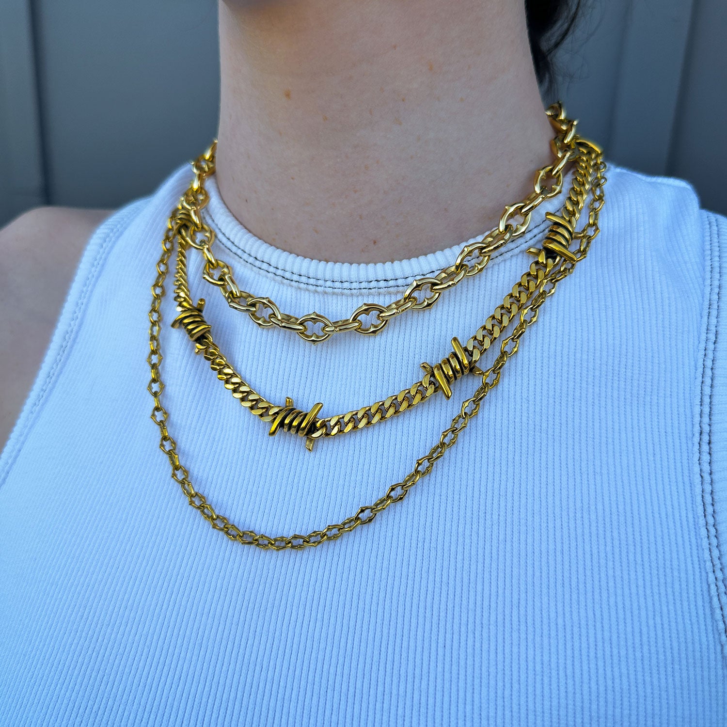 Gothic Gold chain set with spiked and barbed wire jewelry on females neck by statement collective