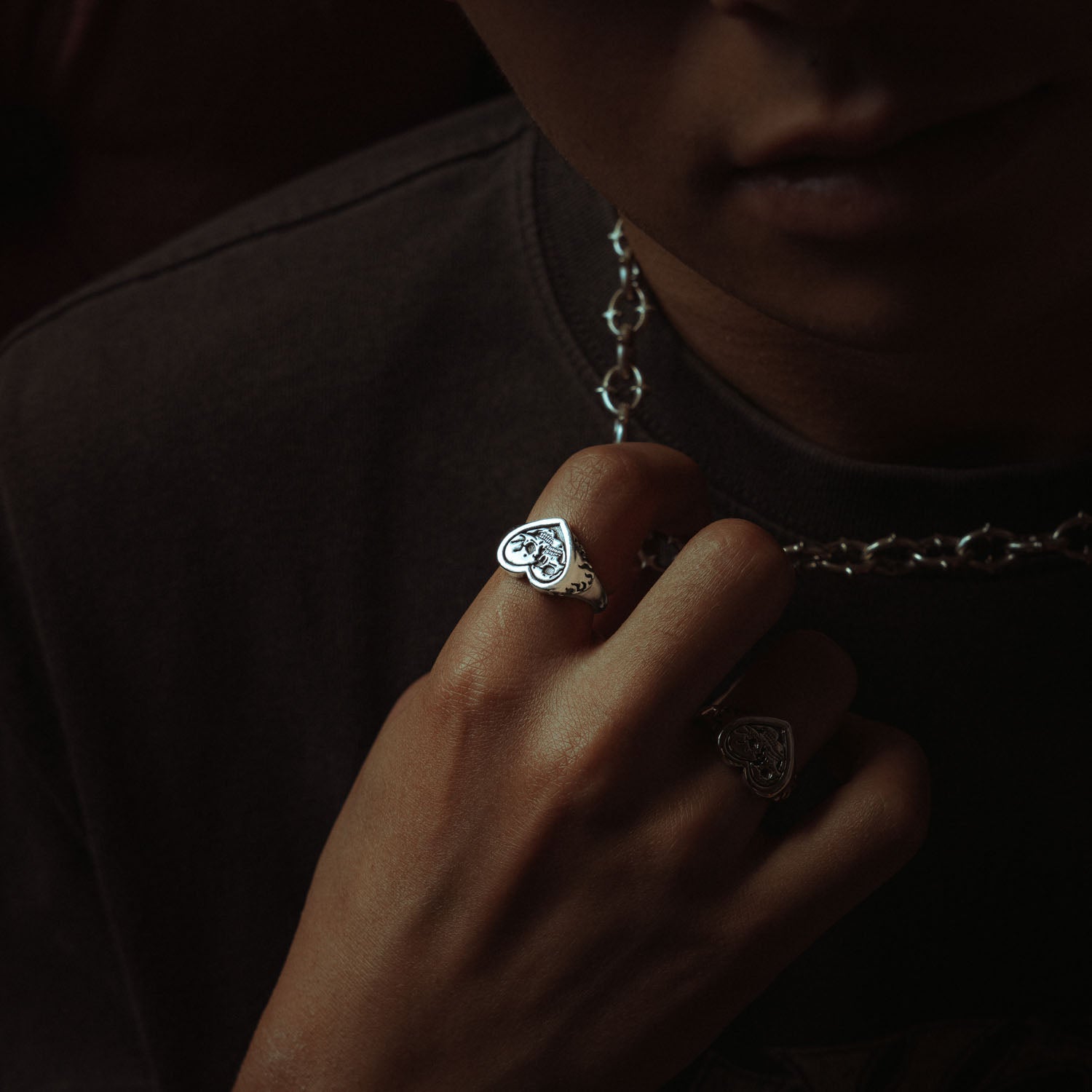 Sterling Silver heart shaped ring with skulls and flames on male model