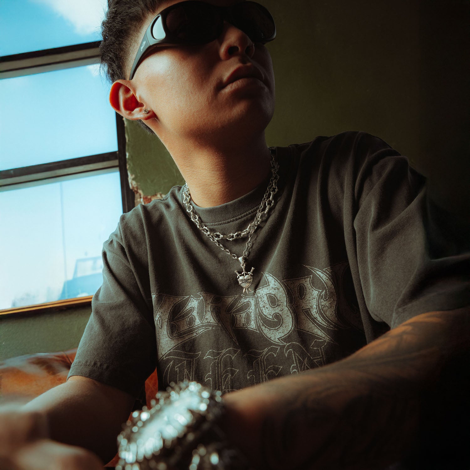 Silver heart pendant with three swords going through it and chain wrapped around it on a spiked chain with thicker spiked chain layered on top