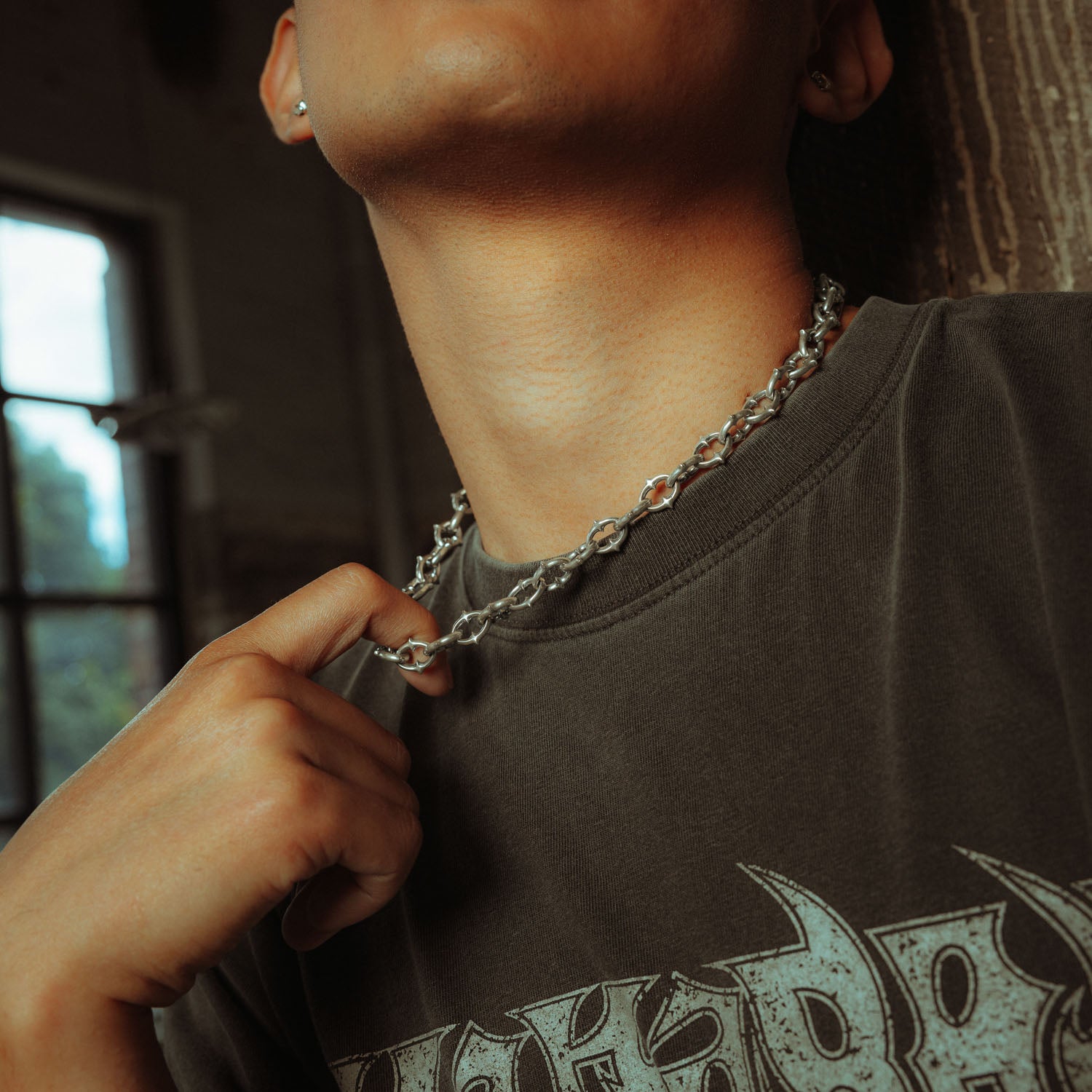9mm spiked chain in sterling silver being held by male model