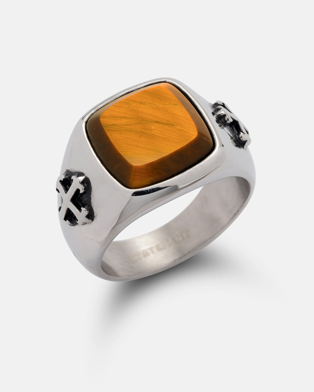Statement Collective Tigers Eye Stone Ring in stainless steel featuring a square tiger’s eye stone and macabre cross-shaped accents on the sides.