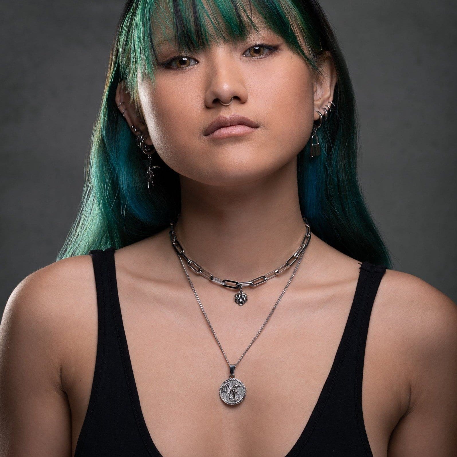 woman with green and blue hair wearing medallion pendant by statement collective
