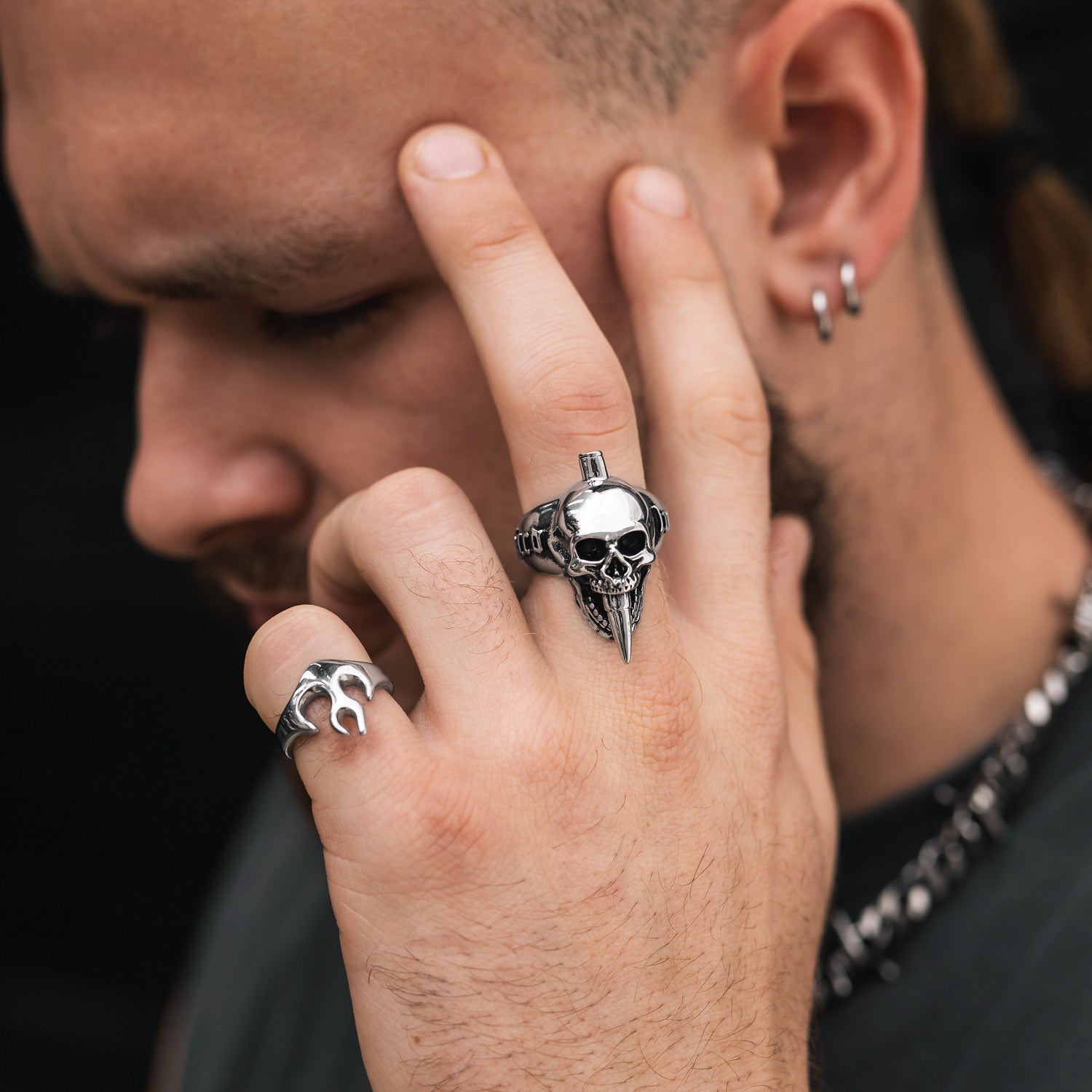 mans hand against temple showing detailed skull ring by statement collective