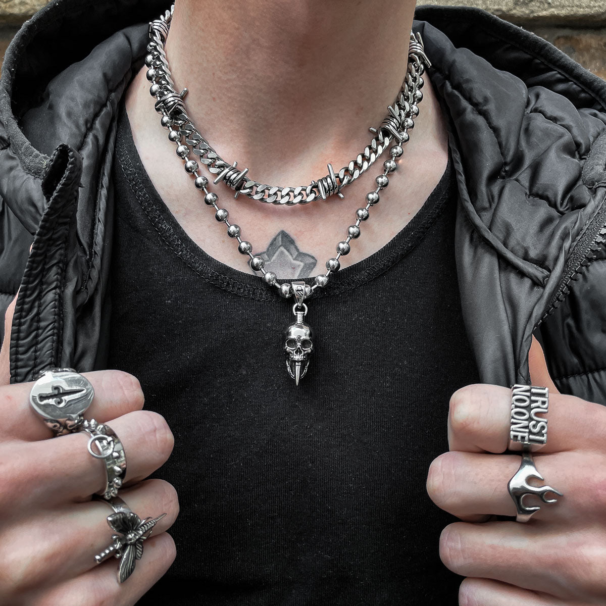 man with black jacket wearing skull pendant necklace by statement collective