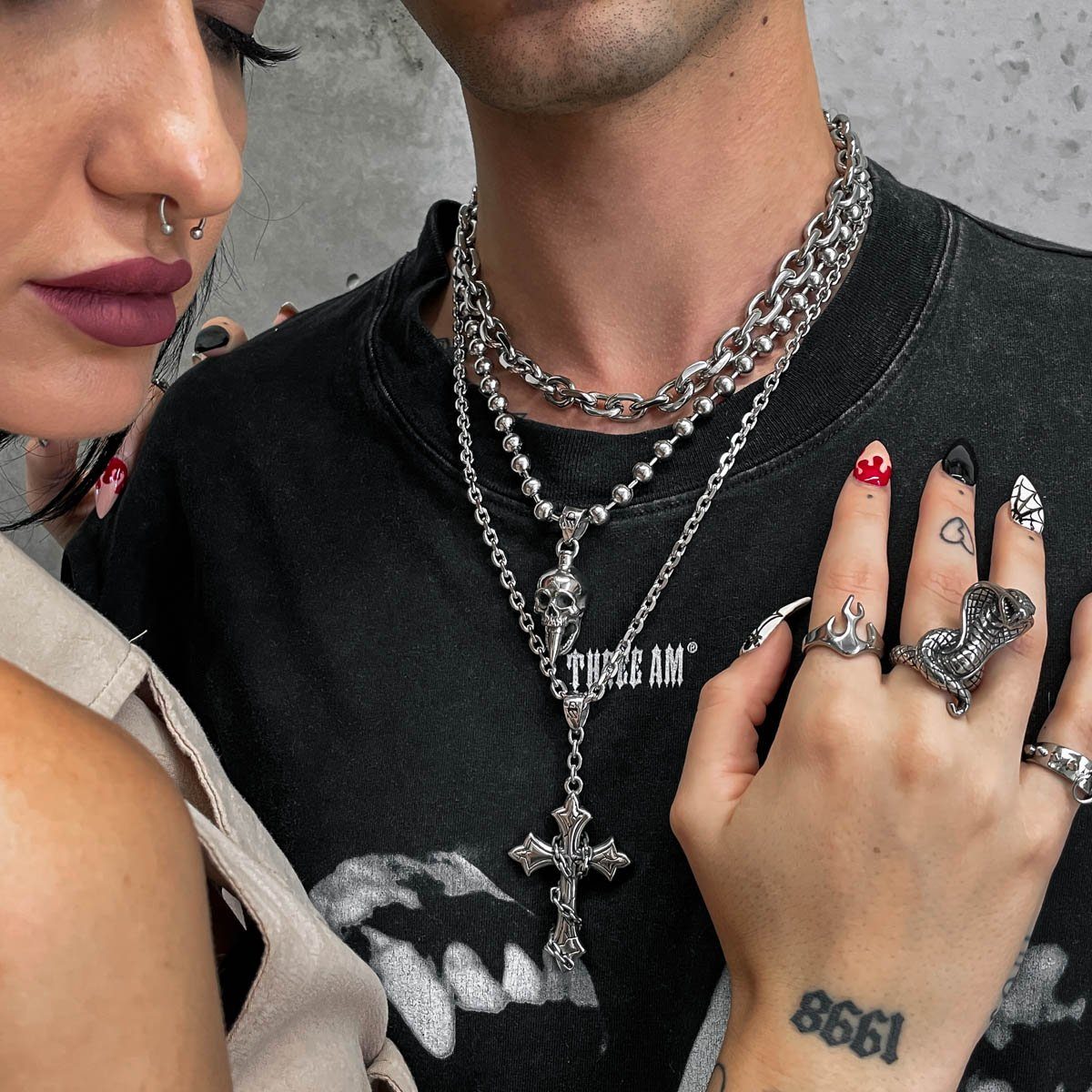 man with black shirt wearing silver chains with skull pendant by statement collective