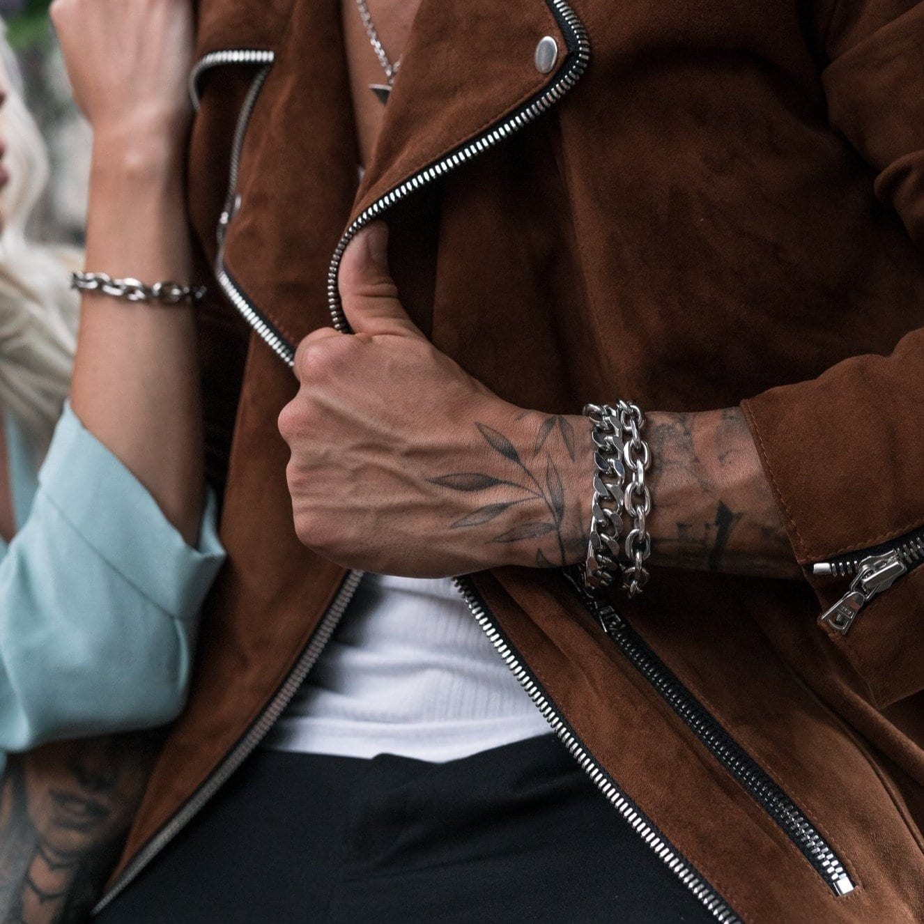 man with brown suede biker jacket wearing silver bracelets