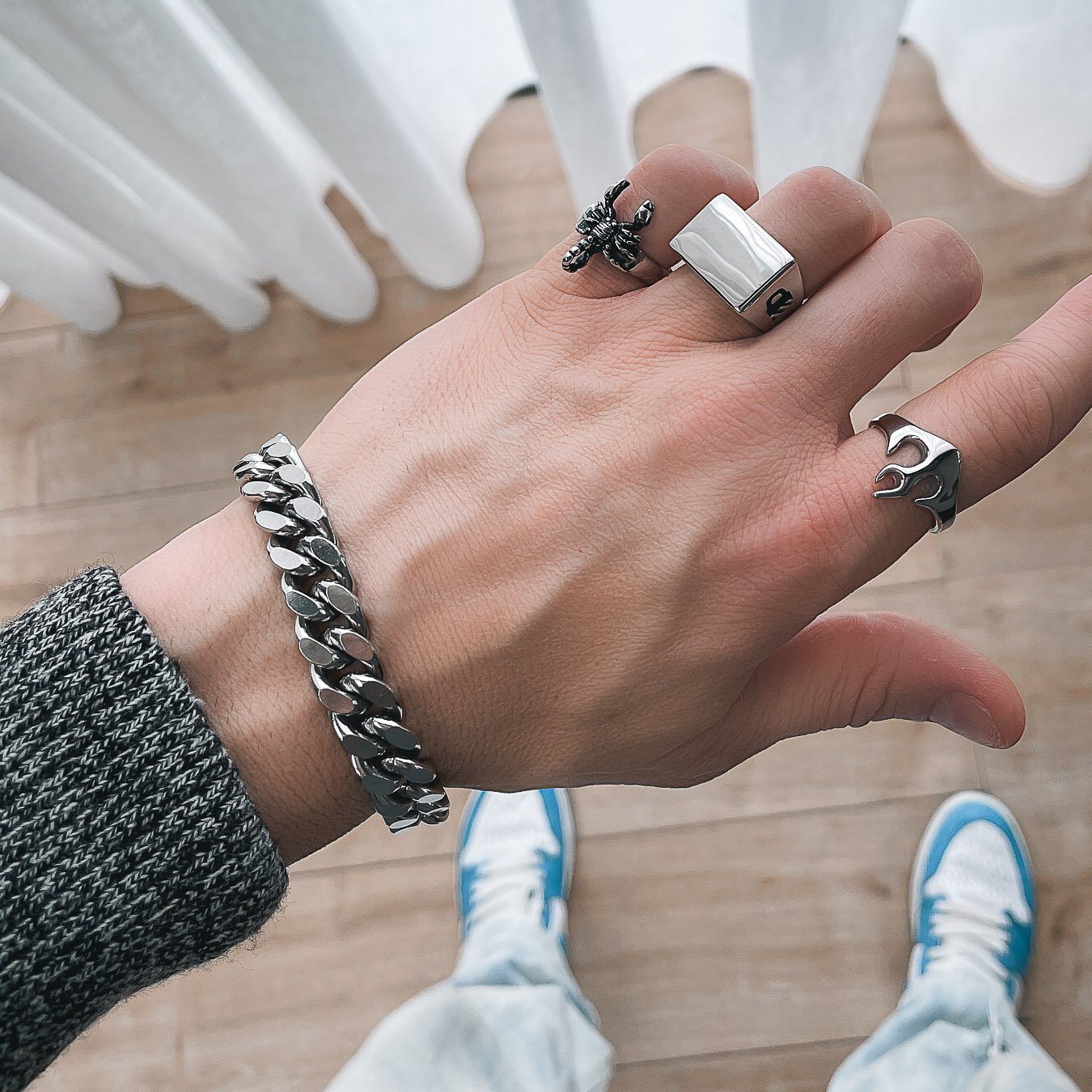 mens hand with silver cuban bracelet and rings by statement collective