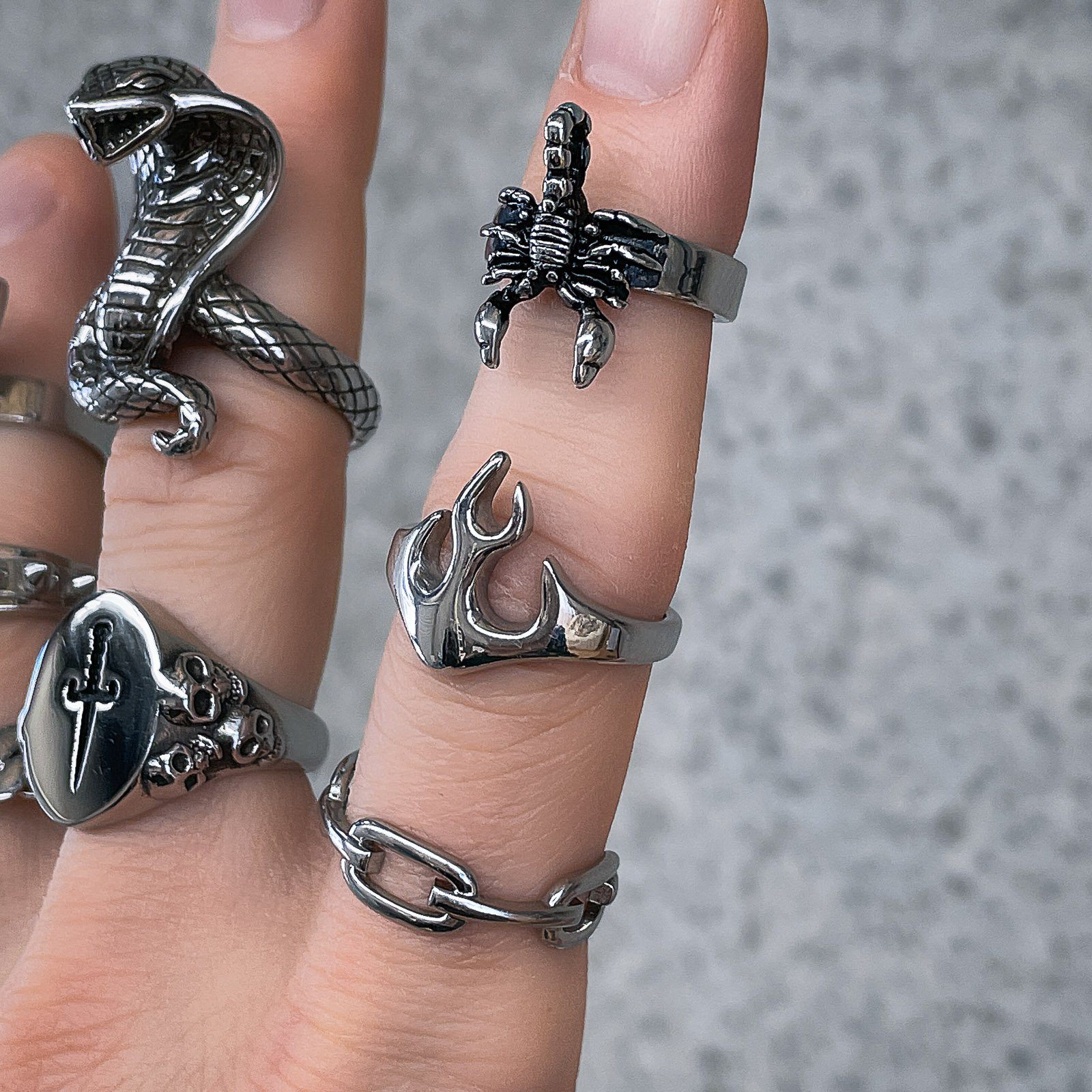heavy rings on mens fingers against stone background