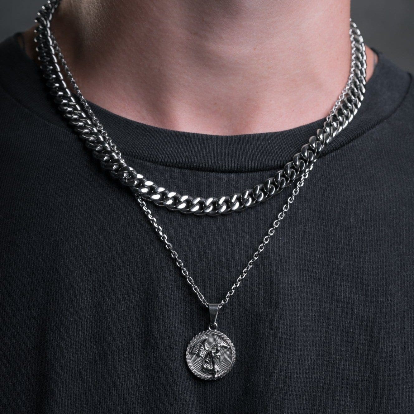 man with necklace chains showing silver medallion