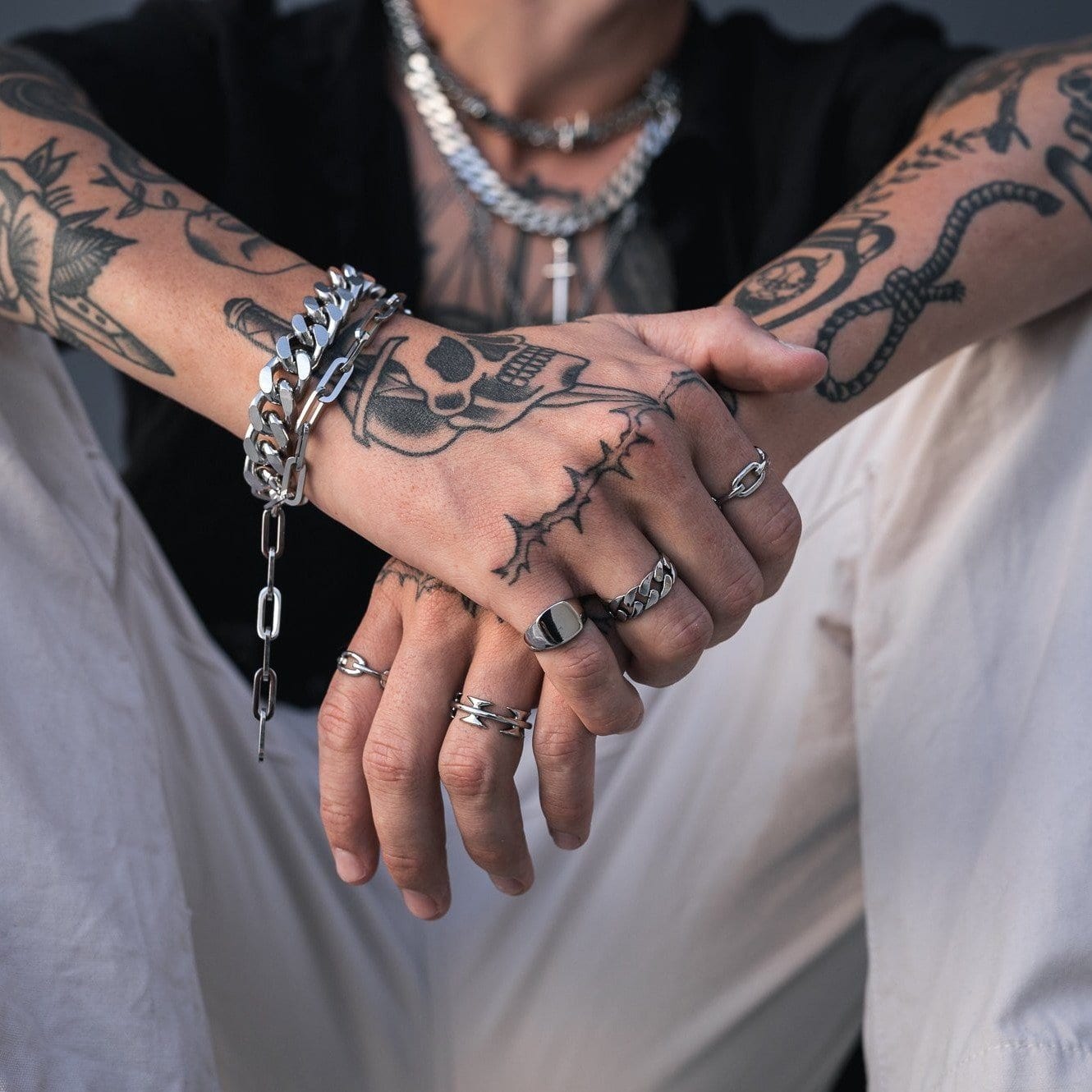 tattooed mens hand with silver cuban ring by statement collective