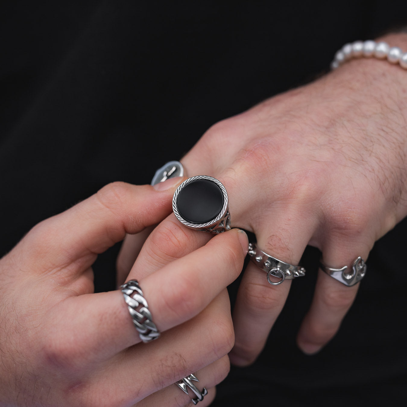 mens hand showing black onyx stone signet ring by statement collective