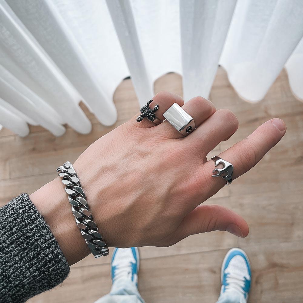 mens hand with shiny rectangle signet ring and blue sneakers by statement collective
