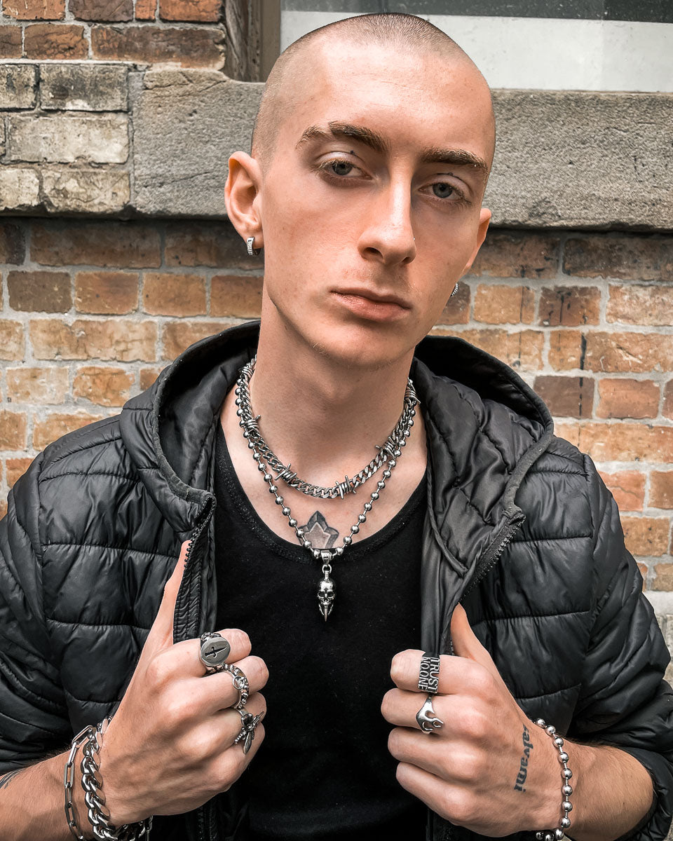 man wearing necklace chains with skull pendant by statement collective