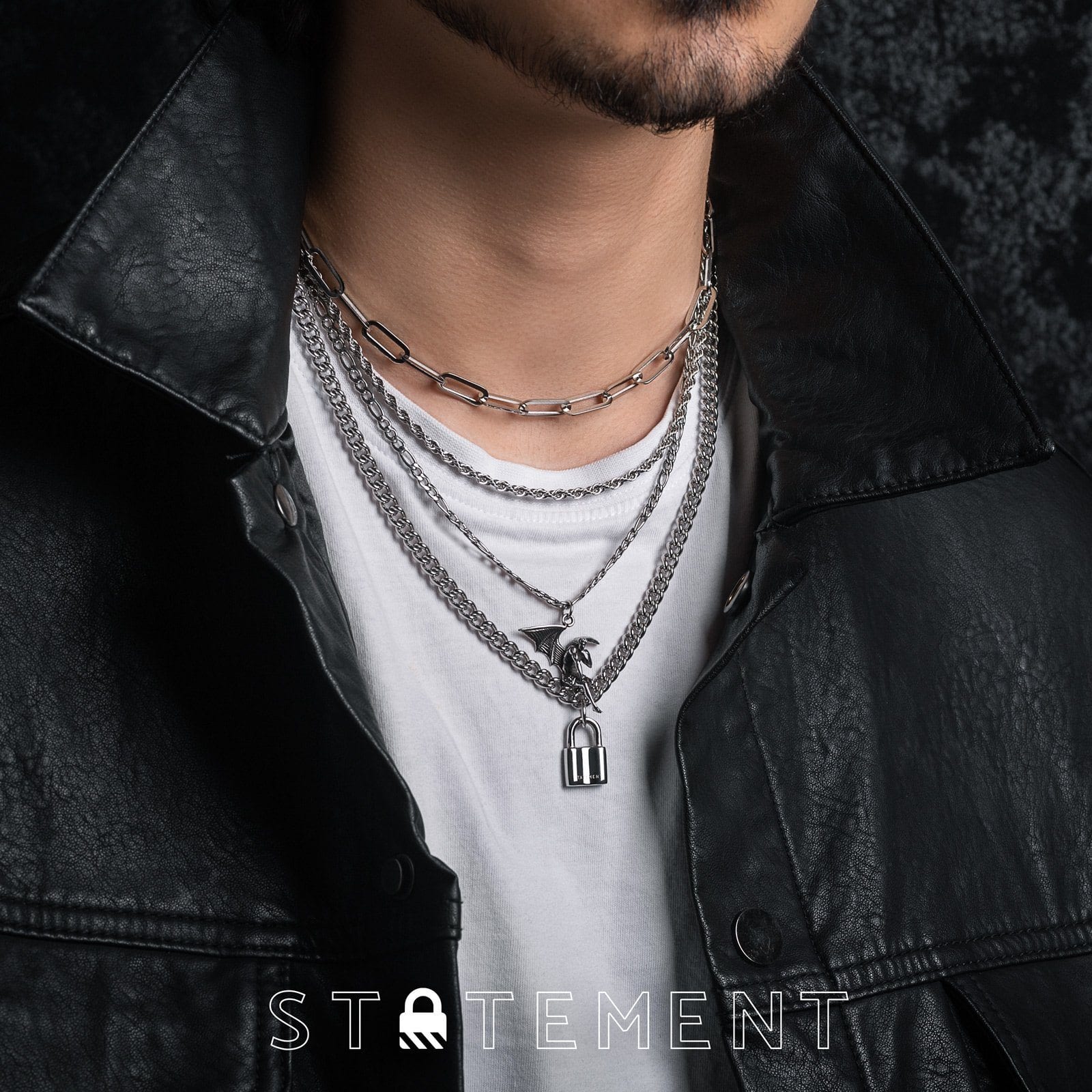 man with white shirt and black jacket wearing fallen angel necklace in layered set by statement collective