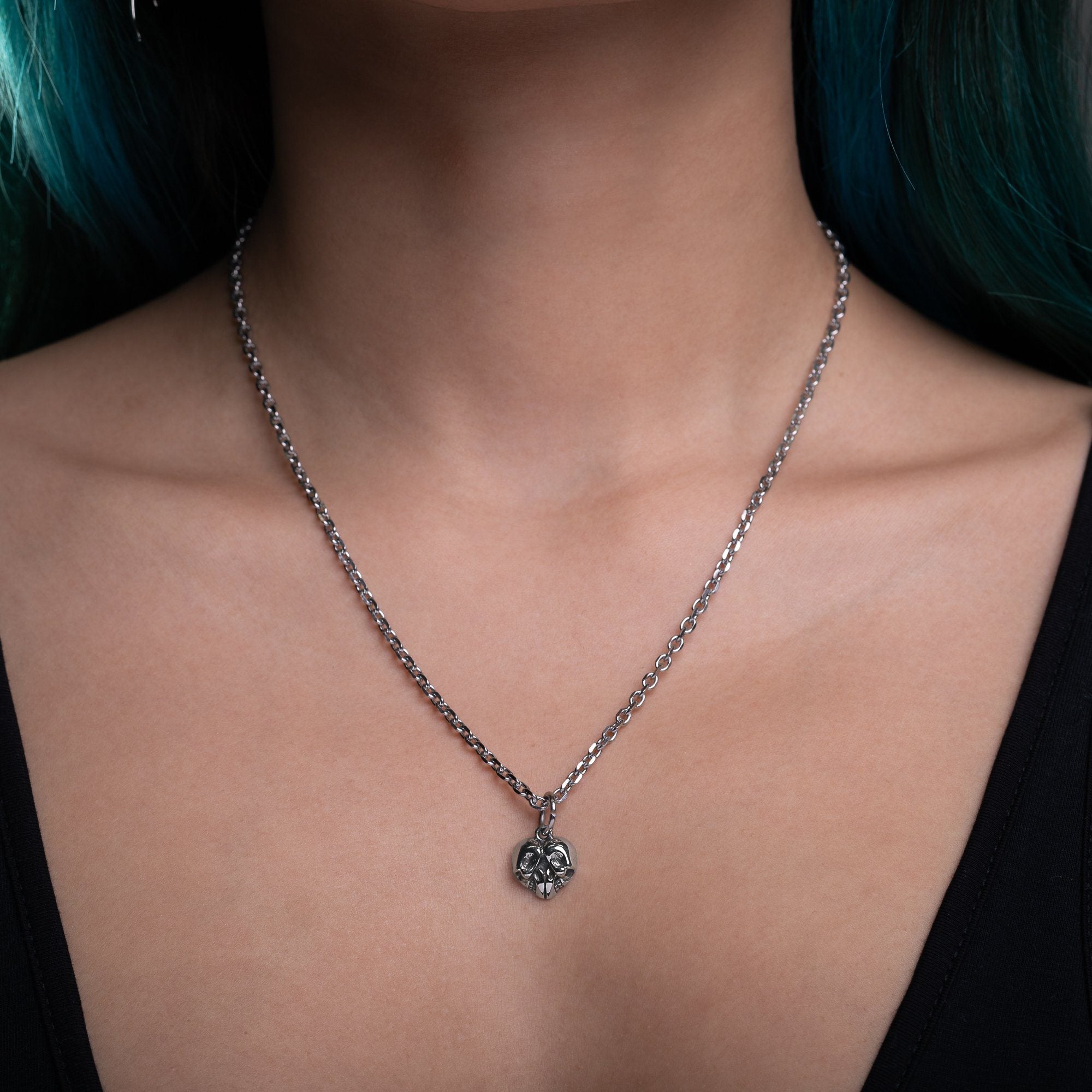 woman wearing skull heart pendant necklace on silver chain by statement collective