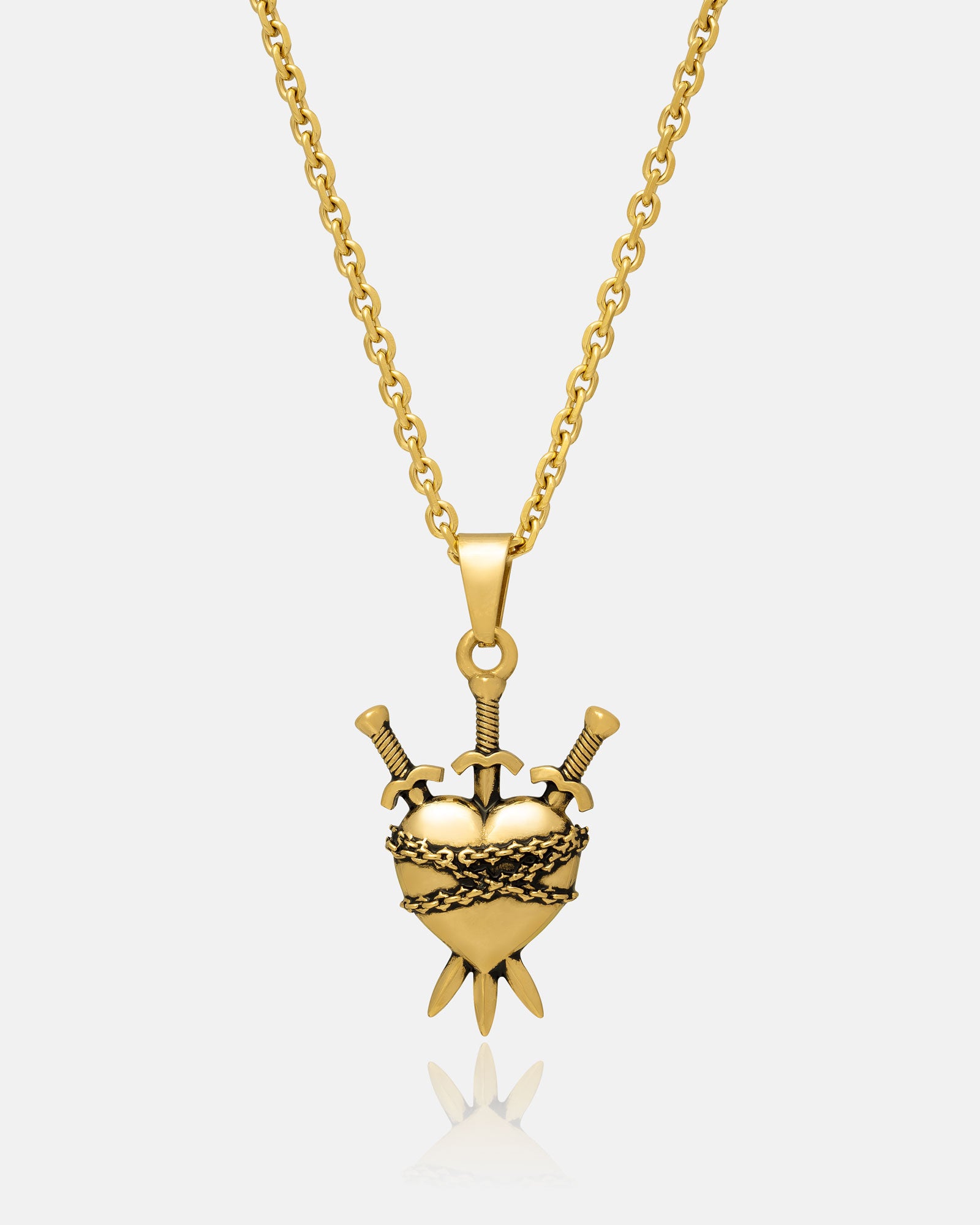 The "3 of Swords" Pendant (Gold) features an 18k gold-plated, heart-shaped charm wrapped in barbed wire and pierced by three swords, inspired by tarot’s Three of Swords card. It hangs from a gold chain, showcased against a white background.