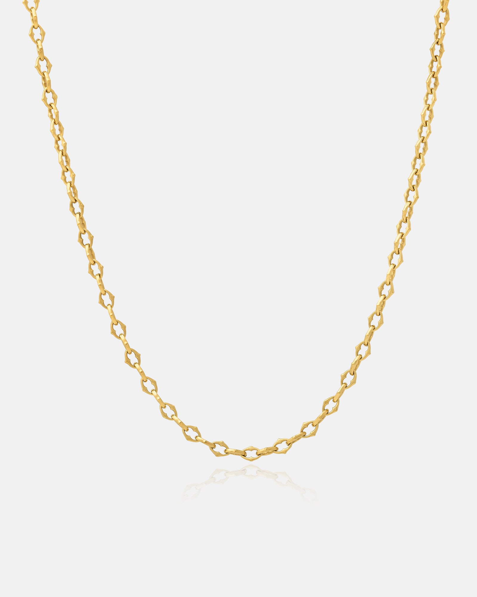 Hanging Gold chain necklace on a light gray background