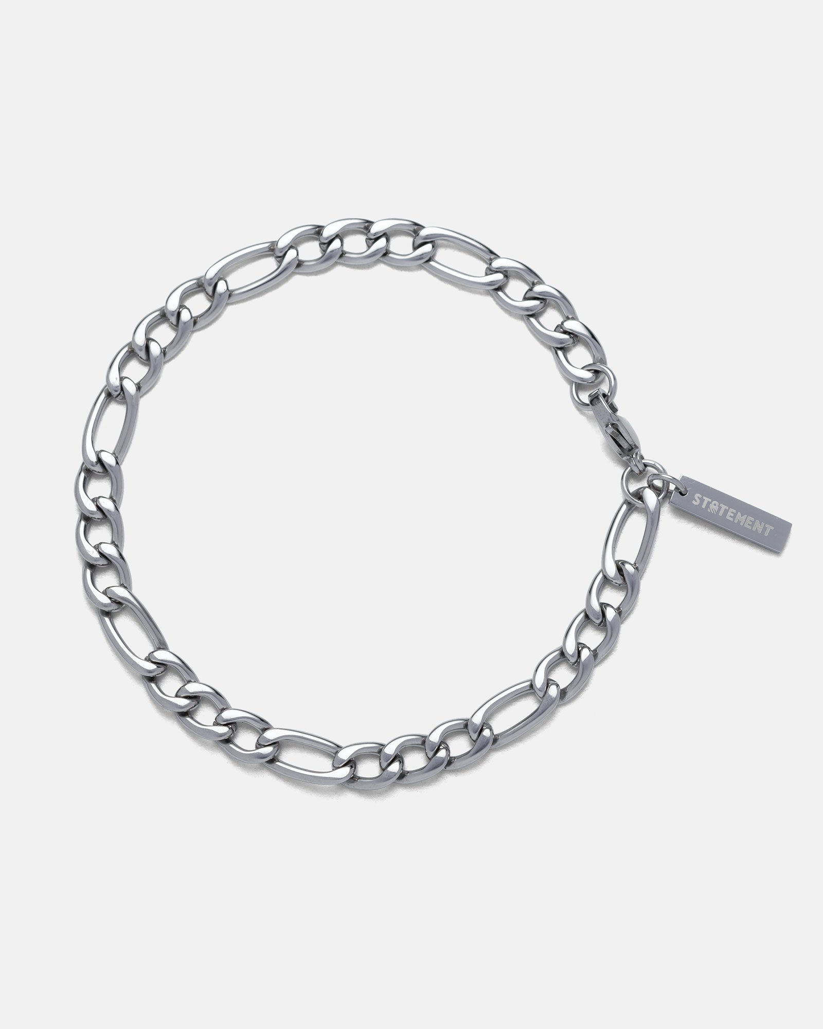 silver 6mm figaro style chain bracelet by statement collective on grey background.
