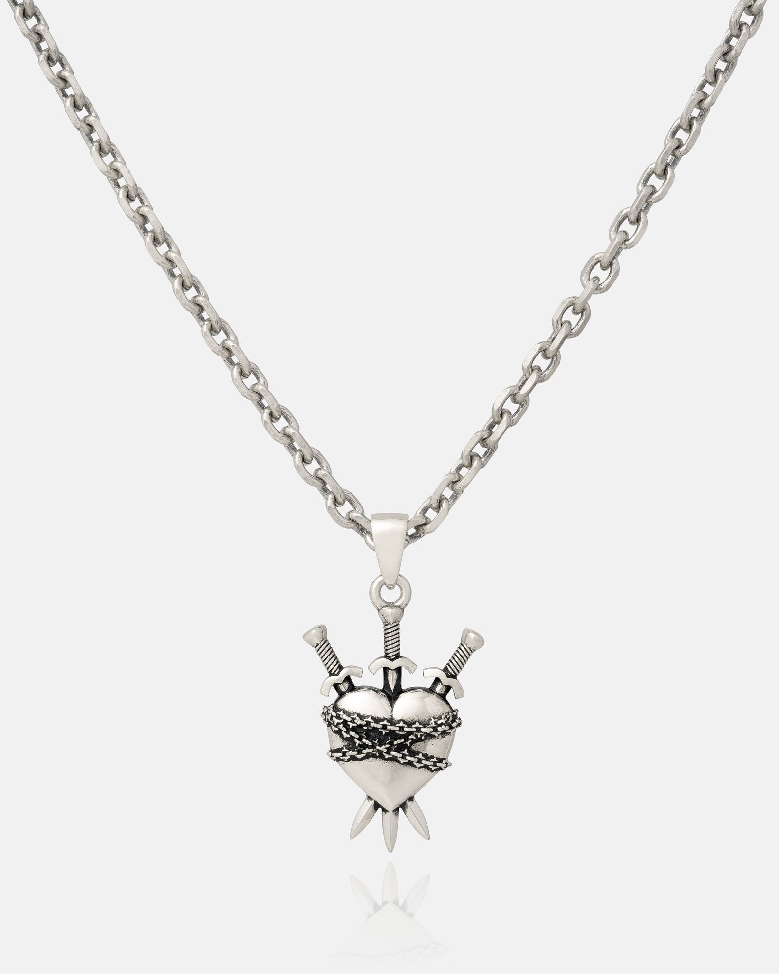 The 925 Sterling Silver "3 of Swords" Pendant features a heart pierced by three swords with ornate detailing, inspired by tarot jewelry—making this striking pendant stand out against a plain white background.