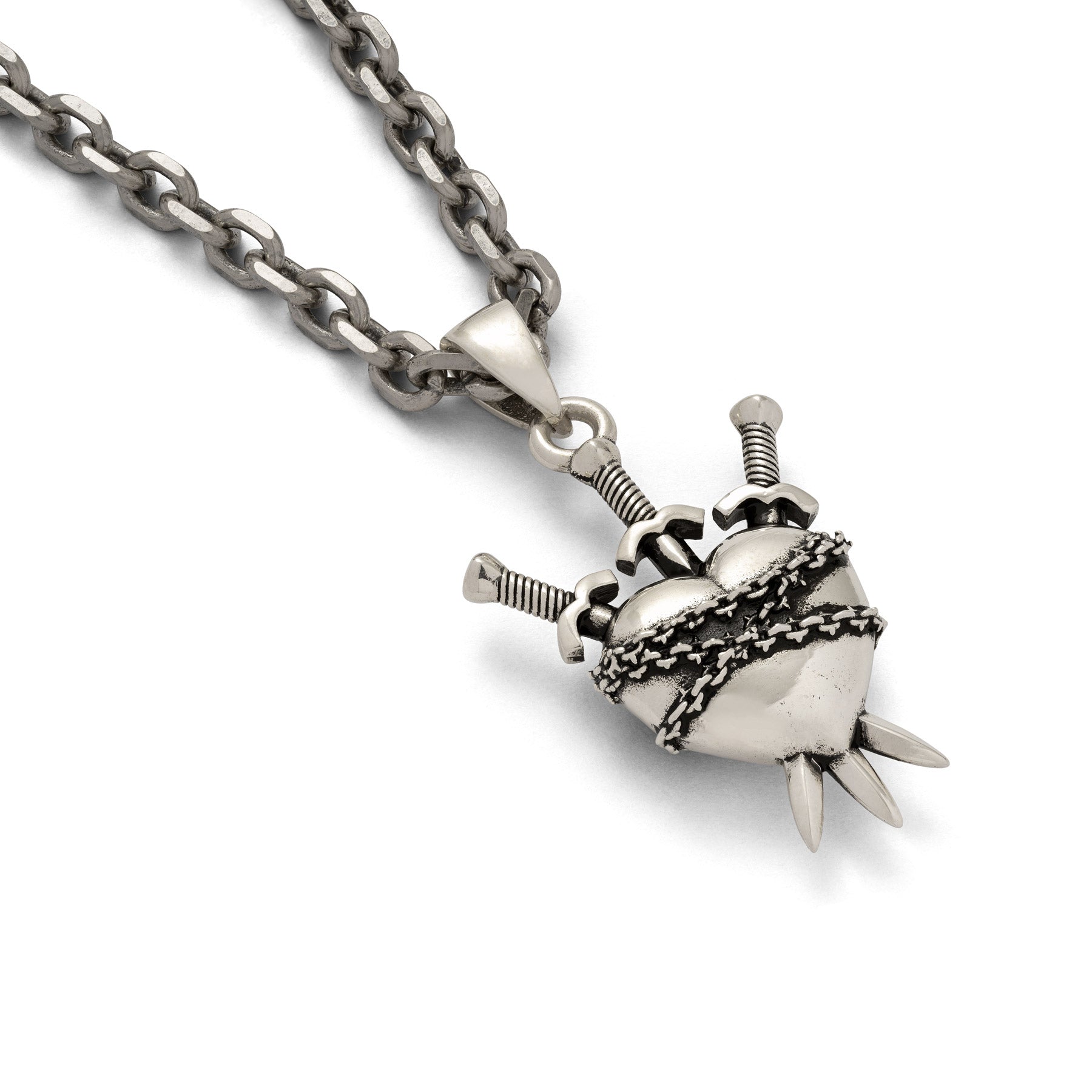 Silver heart pendant with 3 sords going through it and wrapped in chain on whte background 