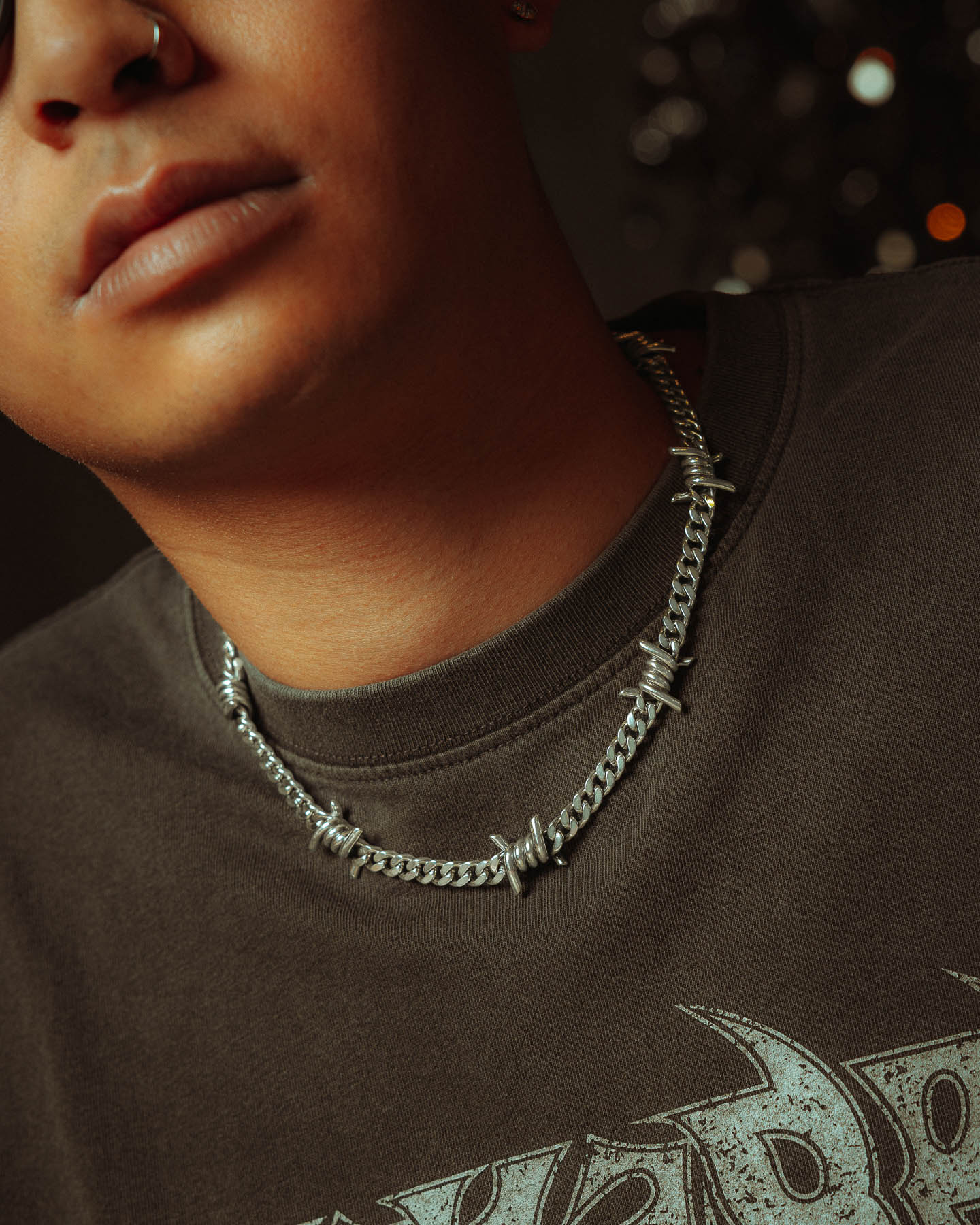 Male model, close up of 6mm barbed wire cuban link chain in 925 sterling silver.