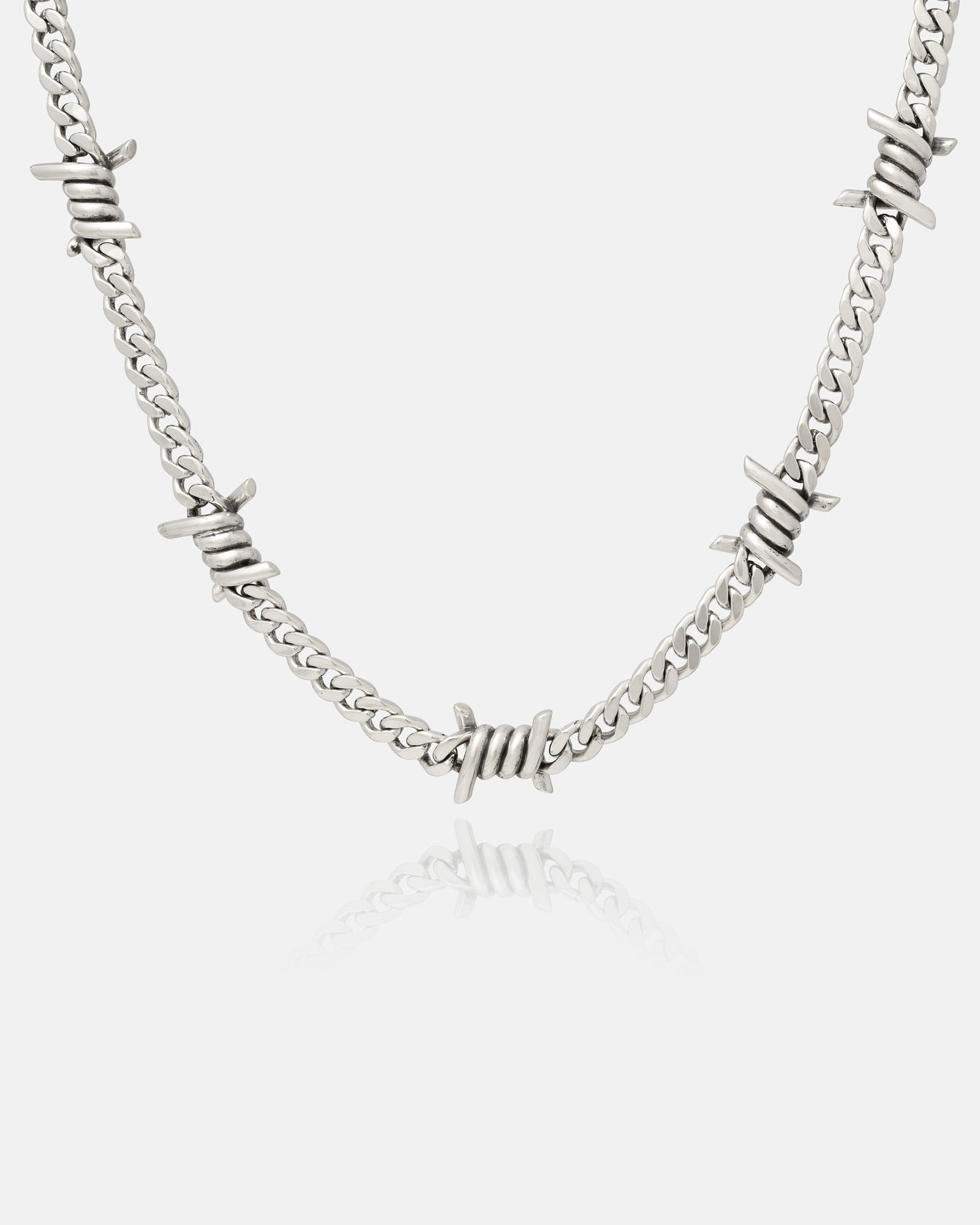 The 925 Sterling Silver 6mm Barbed Wire Cuban Chain showcases evenly spaced barbed wire-style accents on a sleek chain, displayed against a white background.