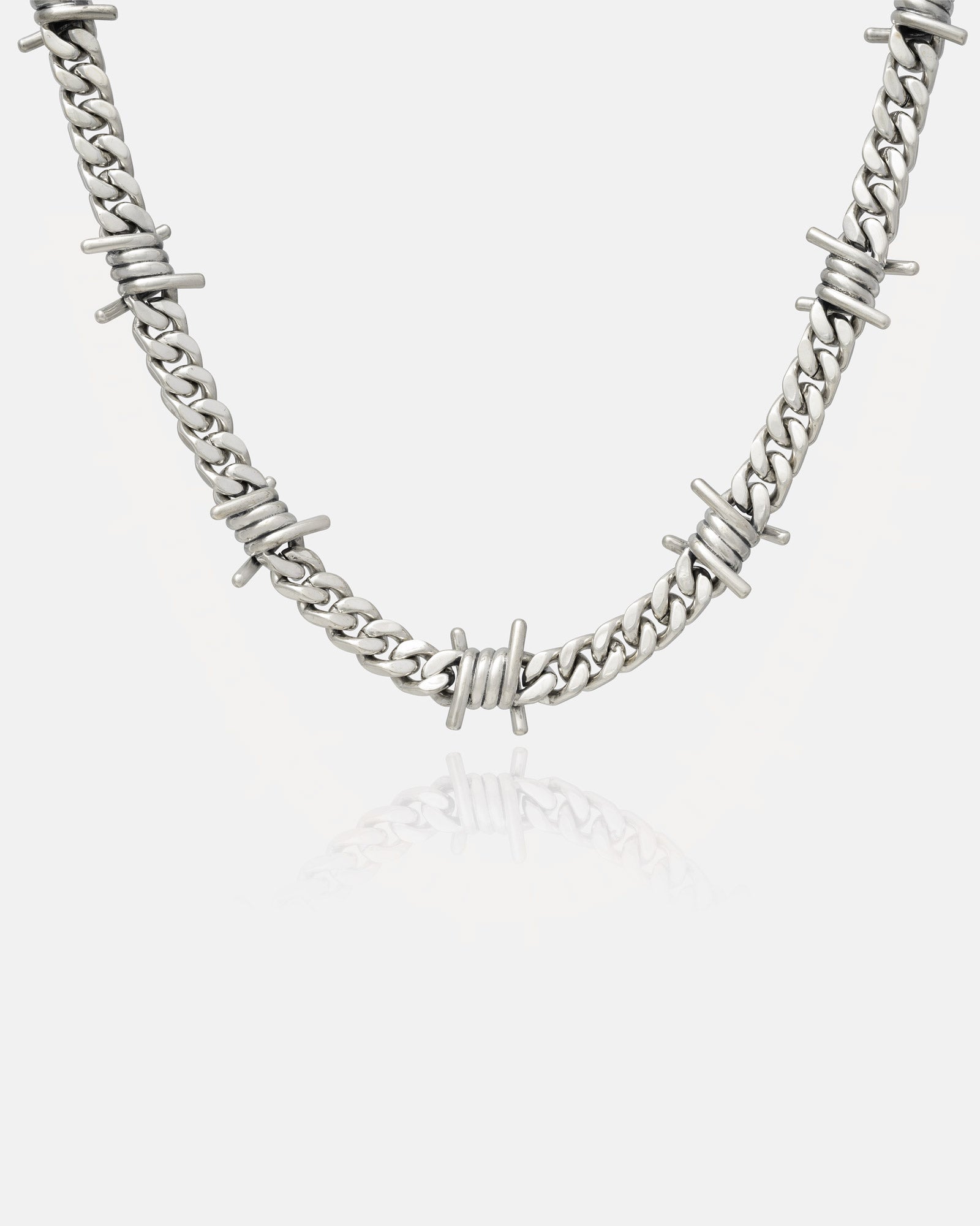 Hanging silver chain barbed wire necklace on grey background