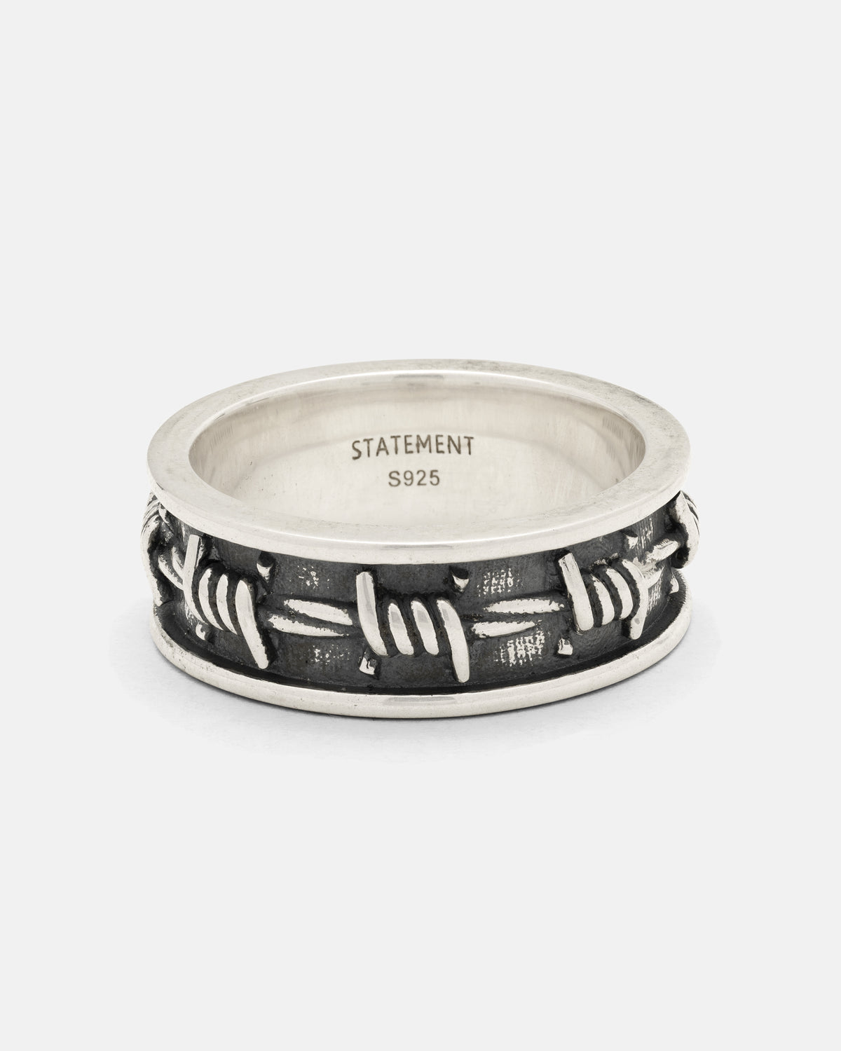 Introducing the 925 Sterling Silver Barbed Wire Ring from Statement Collective—a striking piece crafted in sterling silver with a realistic 3D barbed wire design. This bold ring features “STATEMENT” and “S925” engraved on the inner band, making it ideal for stacking or wearing solo for a daring look.