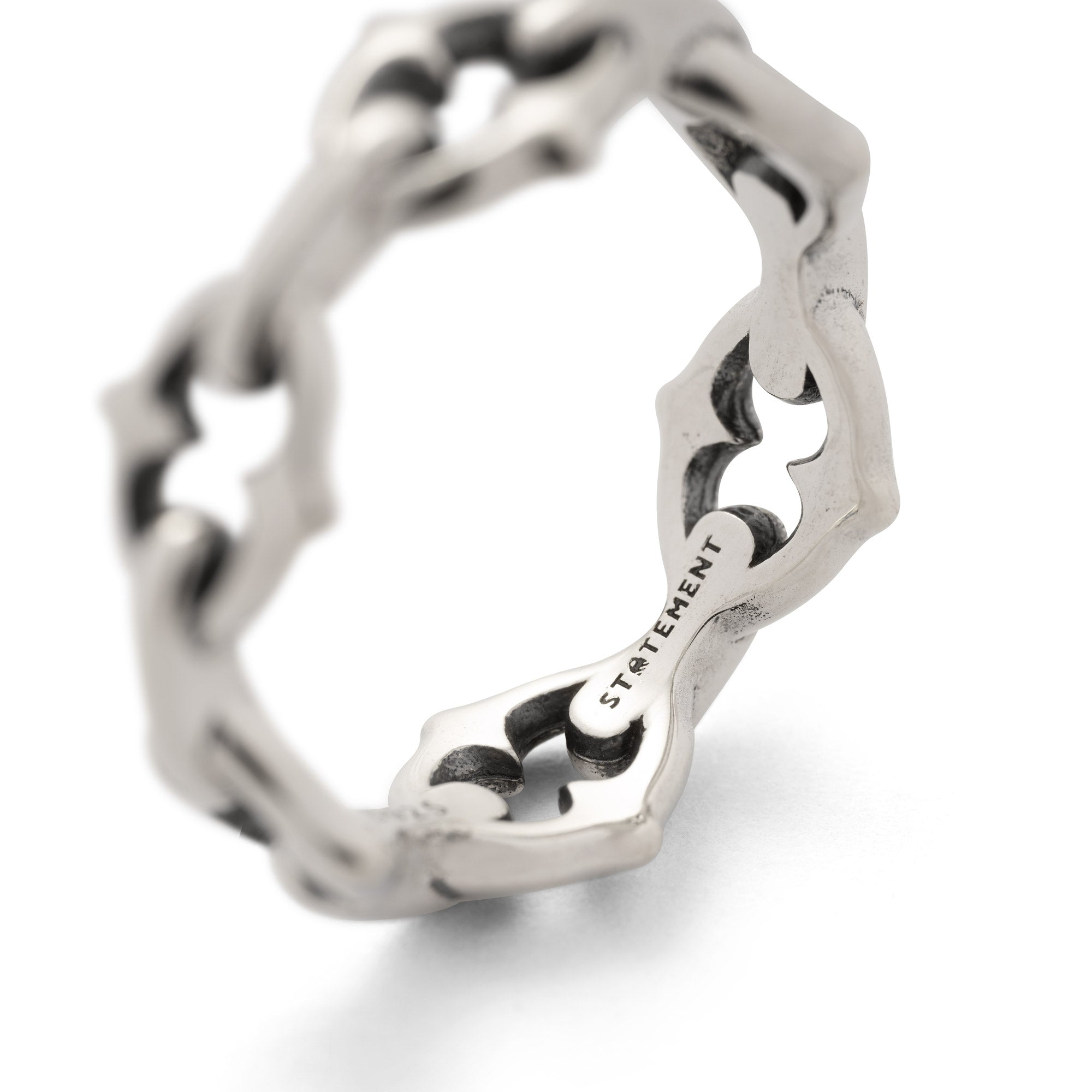 Sterling silver ring with spiked cable links on white background 
