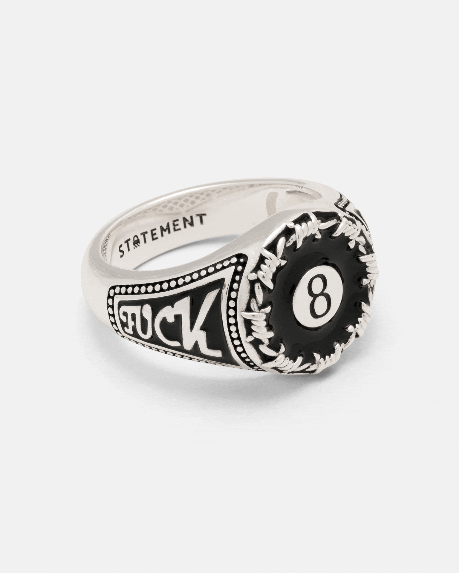 Statement Collective 925 Sterling Silver Lucky Shot Ring featuring a black eight-ball graphic, surrounded by a barbed wire design and inscribed with the word FUCK on the side.