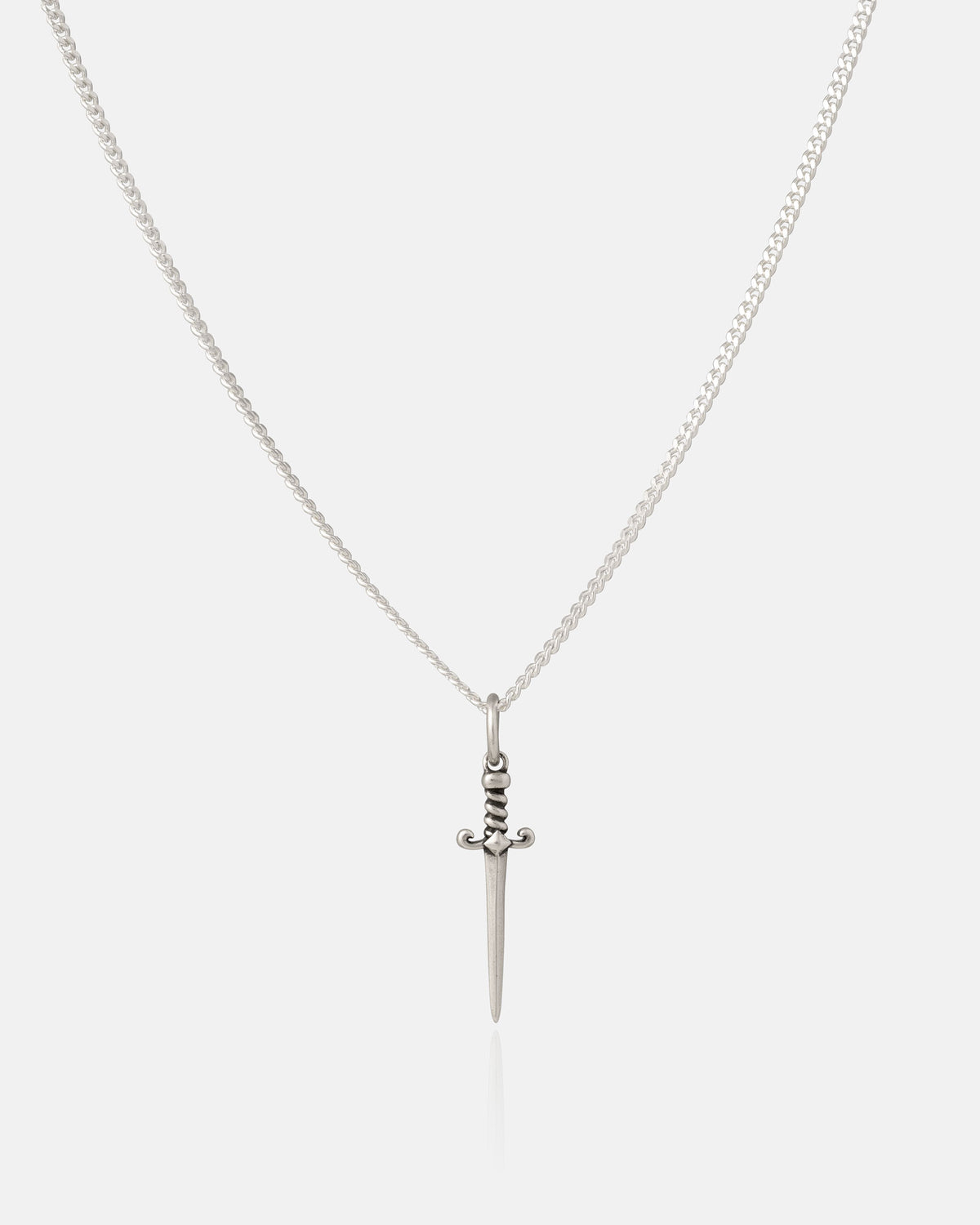 The 925 Sterling Silver Mini Dagger Pendant by Statement Collective features a small, intricately detailed dagger-shaped pendant with a straight blade and ornate handle, suspended from a silver chain. Showcased against a plain white background, this striking piece encapsulates the edgy aesthetic of rock jewelry, making it an ideal addition to any sterling silver collection.