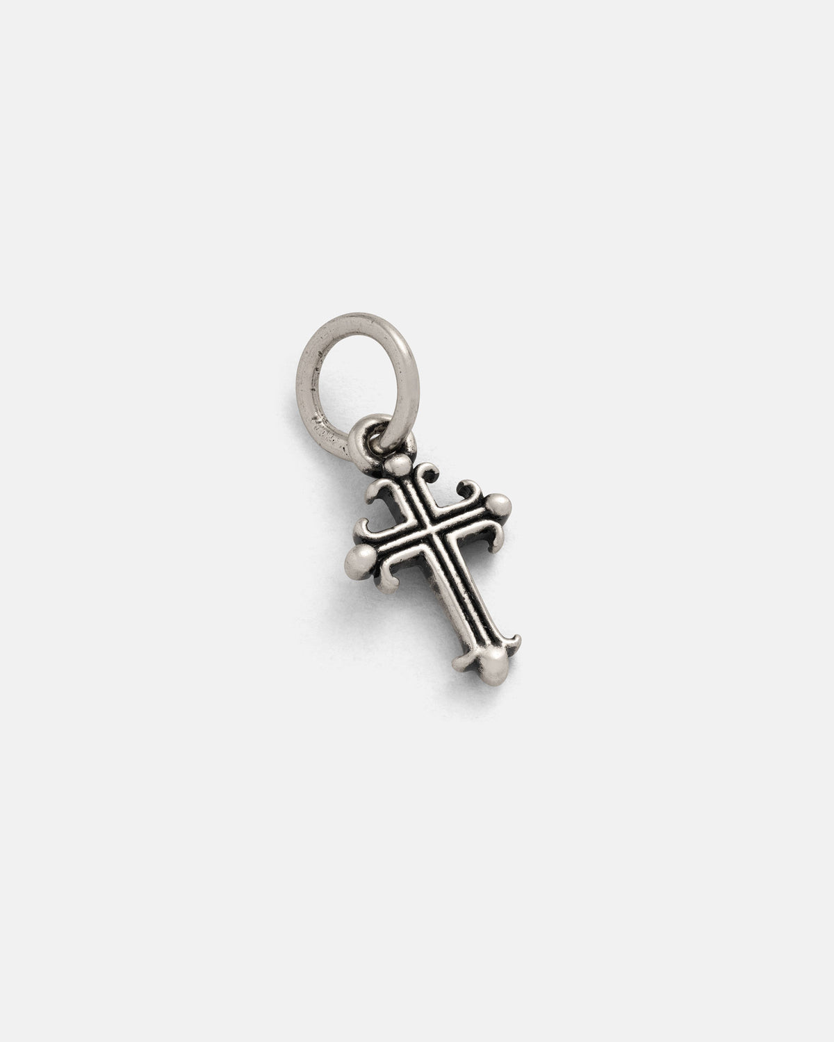 The Statement Collective 925 Sterling Silver Mini French Cross Pendant features decorative detailing and rounded tips, suspended from a circular loop for easy attachment to a chain. Displayed on a plain white background, this elegant piece exemplifies timeless charm and classic craftsmanship in sterling silver jewelry.