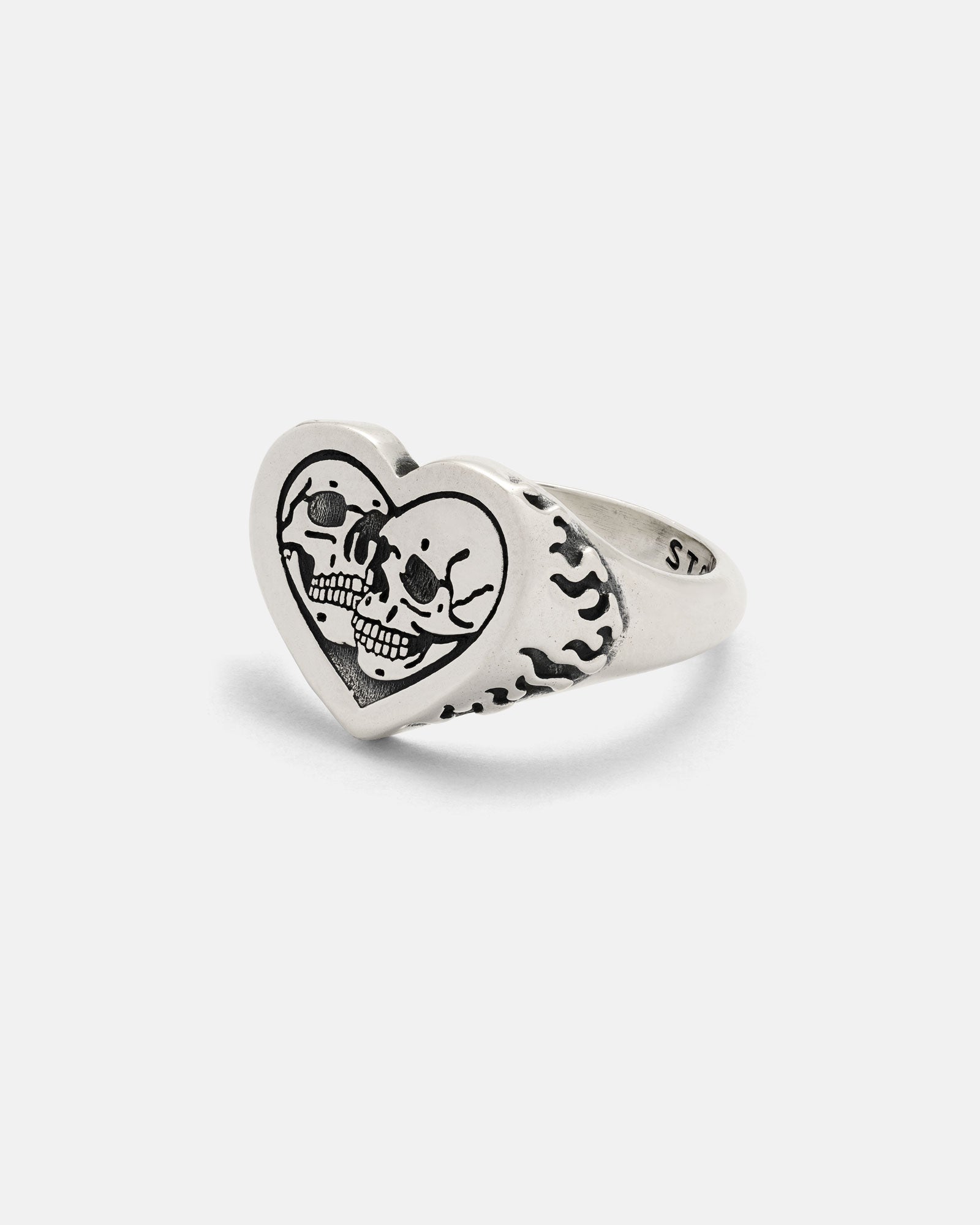 The 925 Sterling Silver Skull Heart Ring features a handcrafted heart-shaped face with engraved skulls and crossbones, while the band boasts a striking flame design for a bold statement.