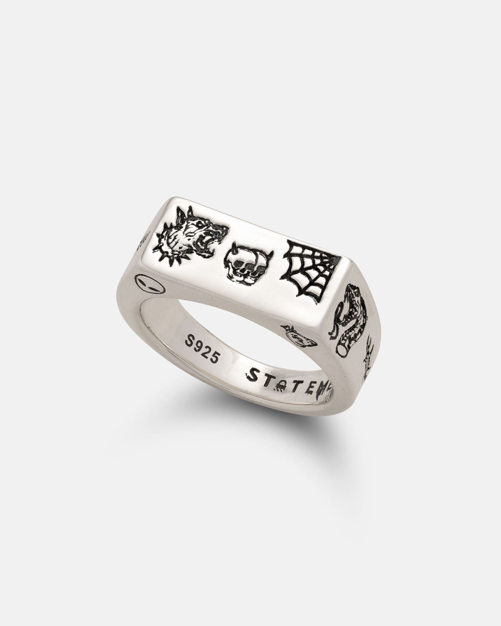 The 925 Sterling Silver Tattoo Signet Ring by Statement Collective features engraved wolf, skull, spider web, and snake tattoo motifs. "S925" and "STATEM" are laser engraved inside for a distinctive touch.