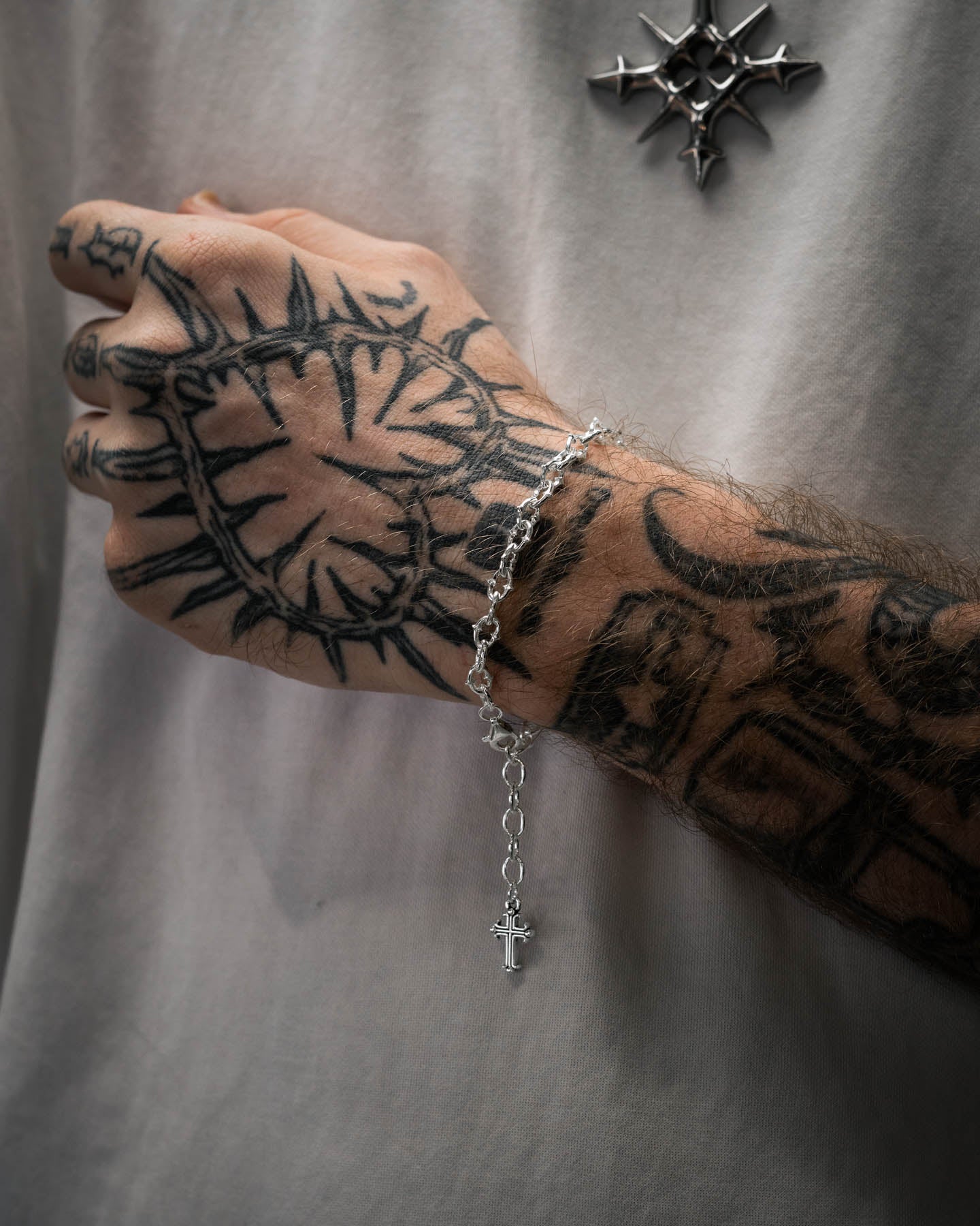 tattooed mens arm with white shirt wearing spiked chain bracelet in 925 sterling silver