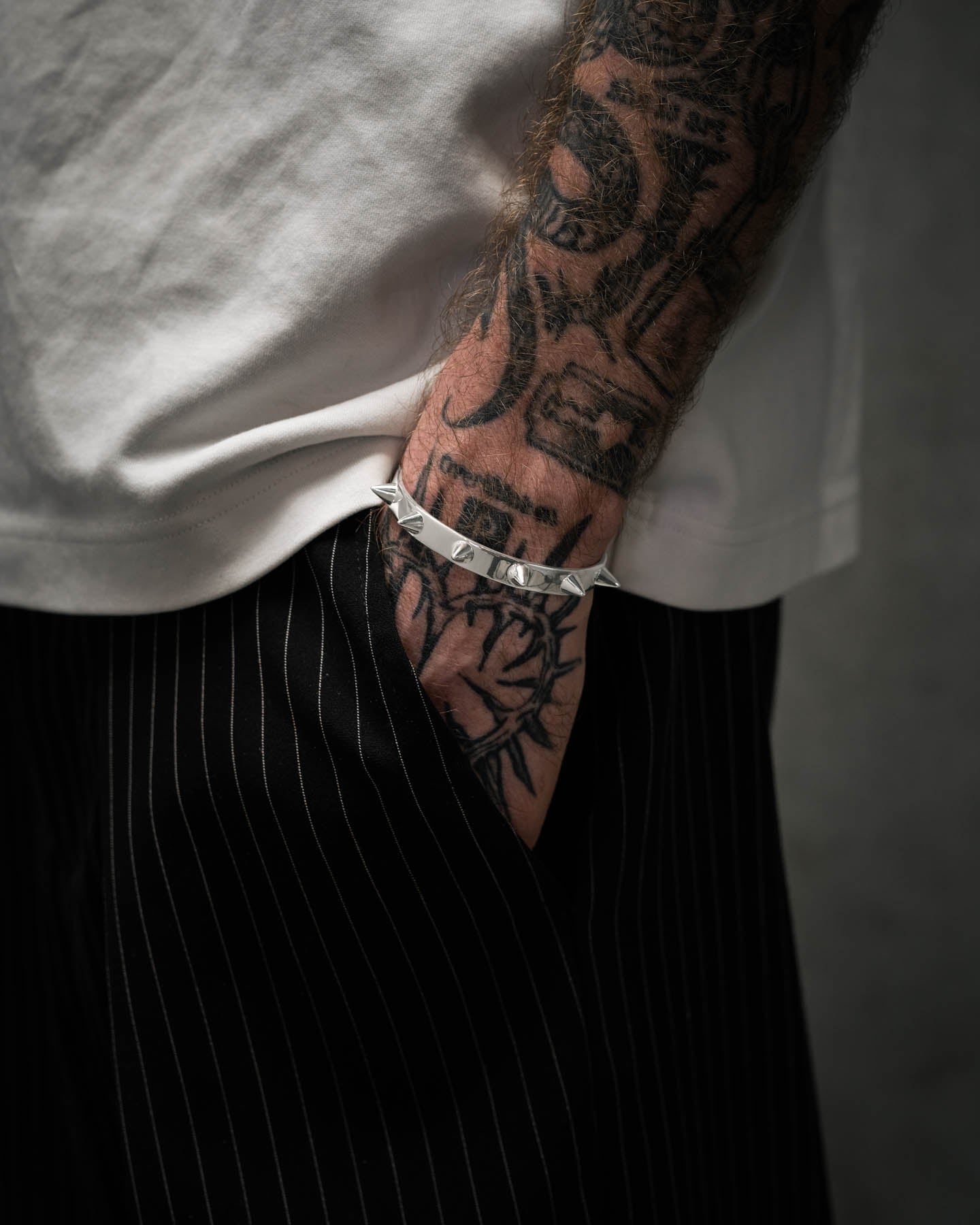 925 sterling silver cuff bracelet with spiked studs around on tattooed man's arm