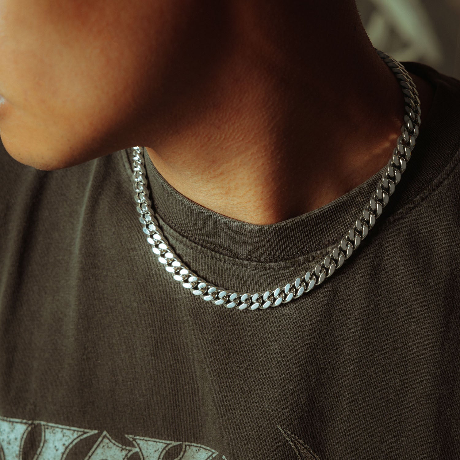 silver 9mm cuban chain on male model in sunglasses and grey shirt 