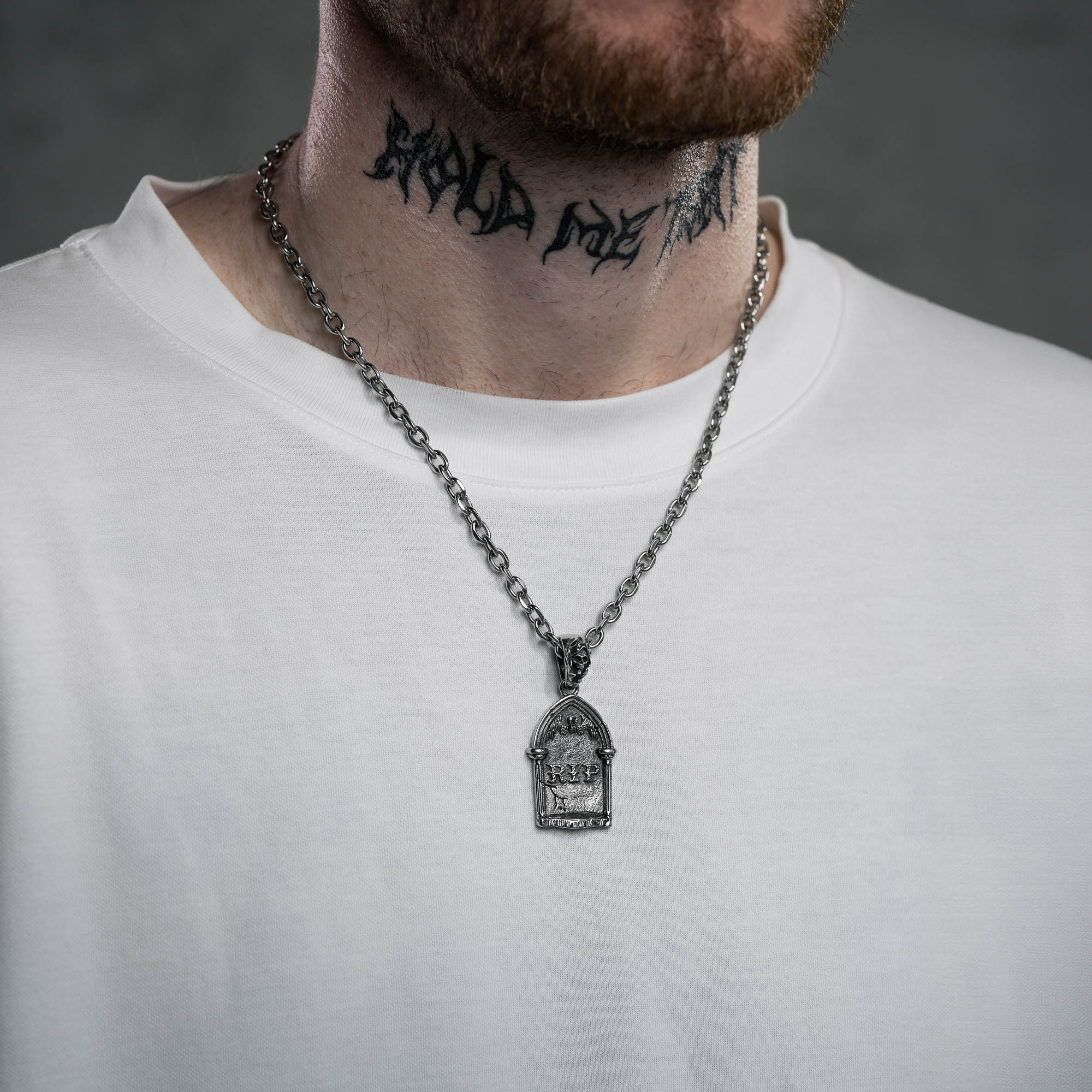 silver Gravestone pendant with Reaper Bale on a cable link chain, on male model with white t shirt and neck tattoo 