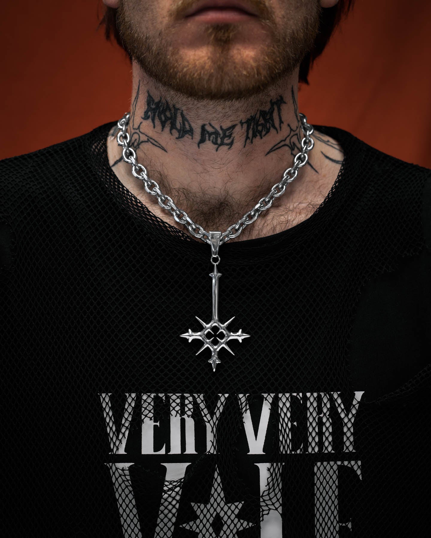 Silver necklace with a star-shaped pendant on tattooed model's neck