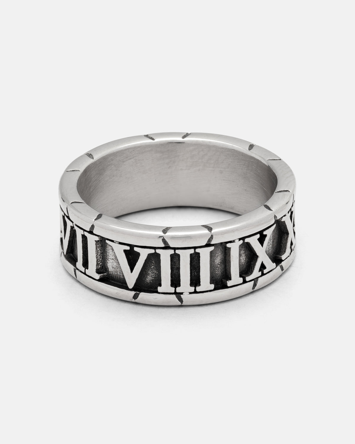 The Numerals Ring by Statement Collective is a striking accessory crafted from polished stainless steel, featuring bold black engraved Roman numerals from VII to XII elegantly wrapped around the band. Perfect as a statement piece or stacking band, this silver ring is beautifully displayed on a crisp white background.