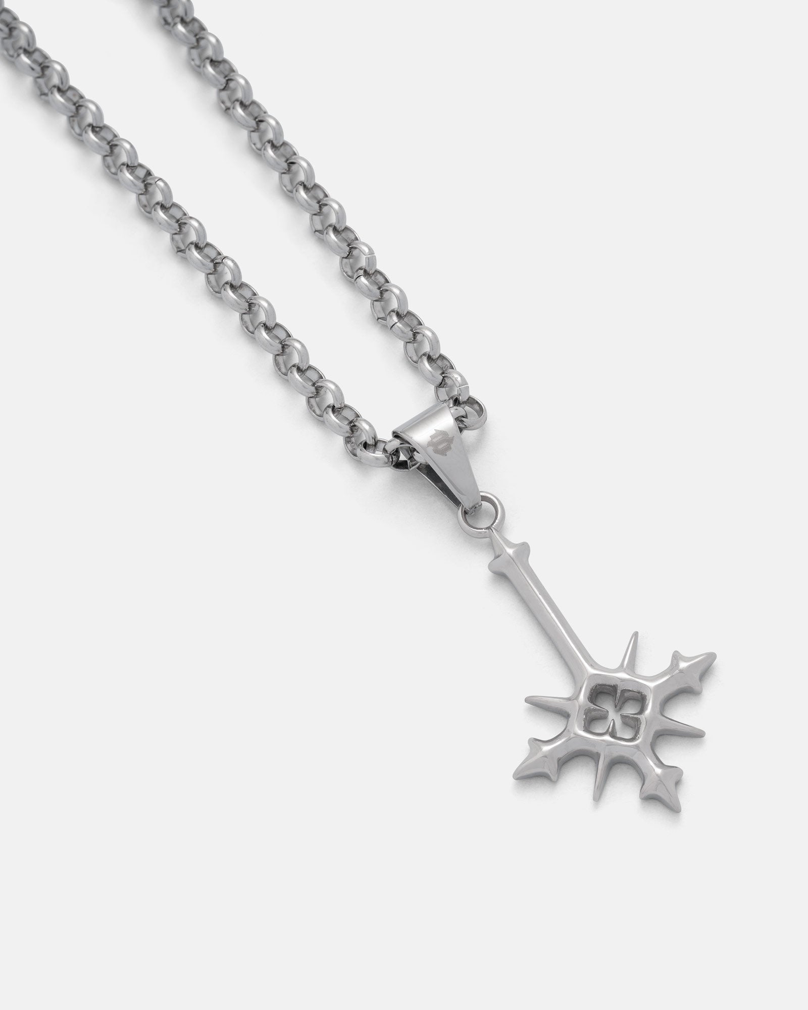 Inverted cross pendant on rolo chain against white background